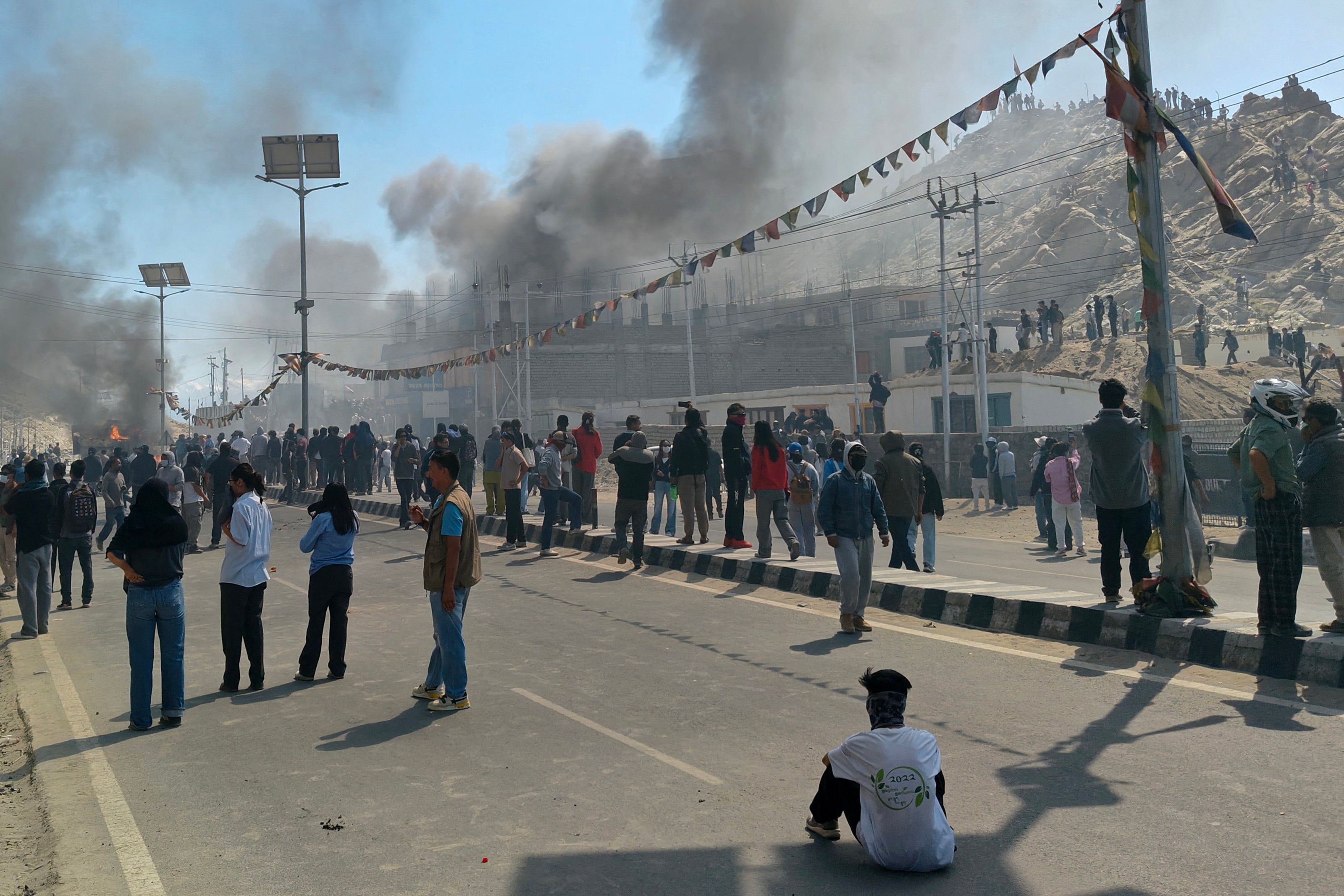 Smoke rises from a police car torched by protesters near the BJP office in Leh