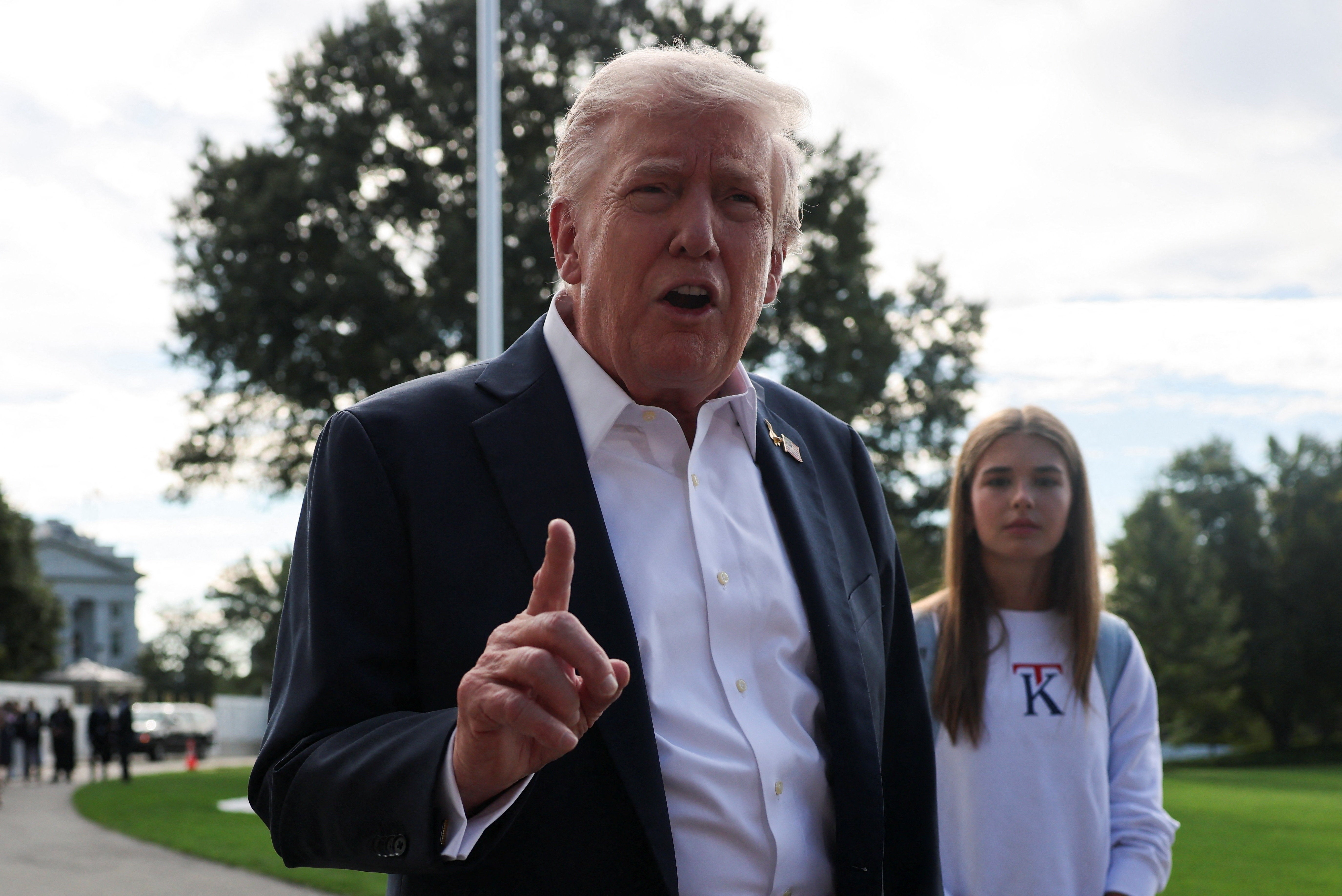 U.S. President Donald Trump speaks to the media as his granddaughter Kai Madison Trump looks on before departing for travel to New York to attend the Ryder Cup golf tournament, from the White House in Washington, D.C., U.S., September 26, 2025 REUTERS/Jonathan Ernst
