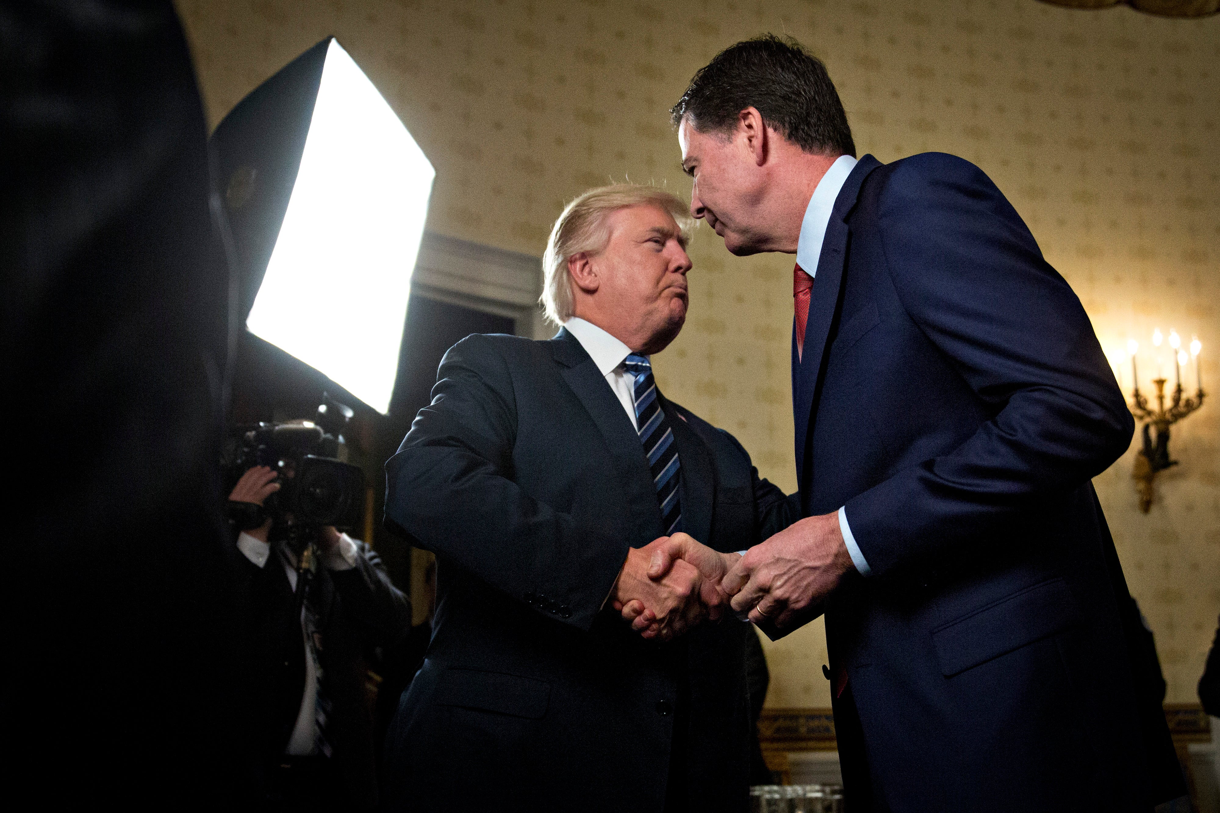 WASHINGTON, DC - JANUARY 22: U.S. President Donald Trump, left, shakes hands with James Comey (Photo by Andrew Harrer-Pool/Getty Images)