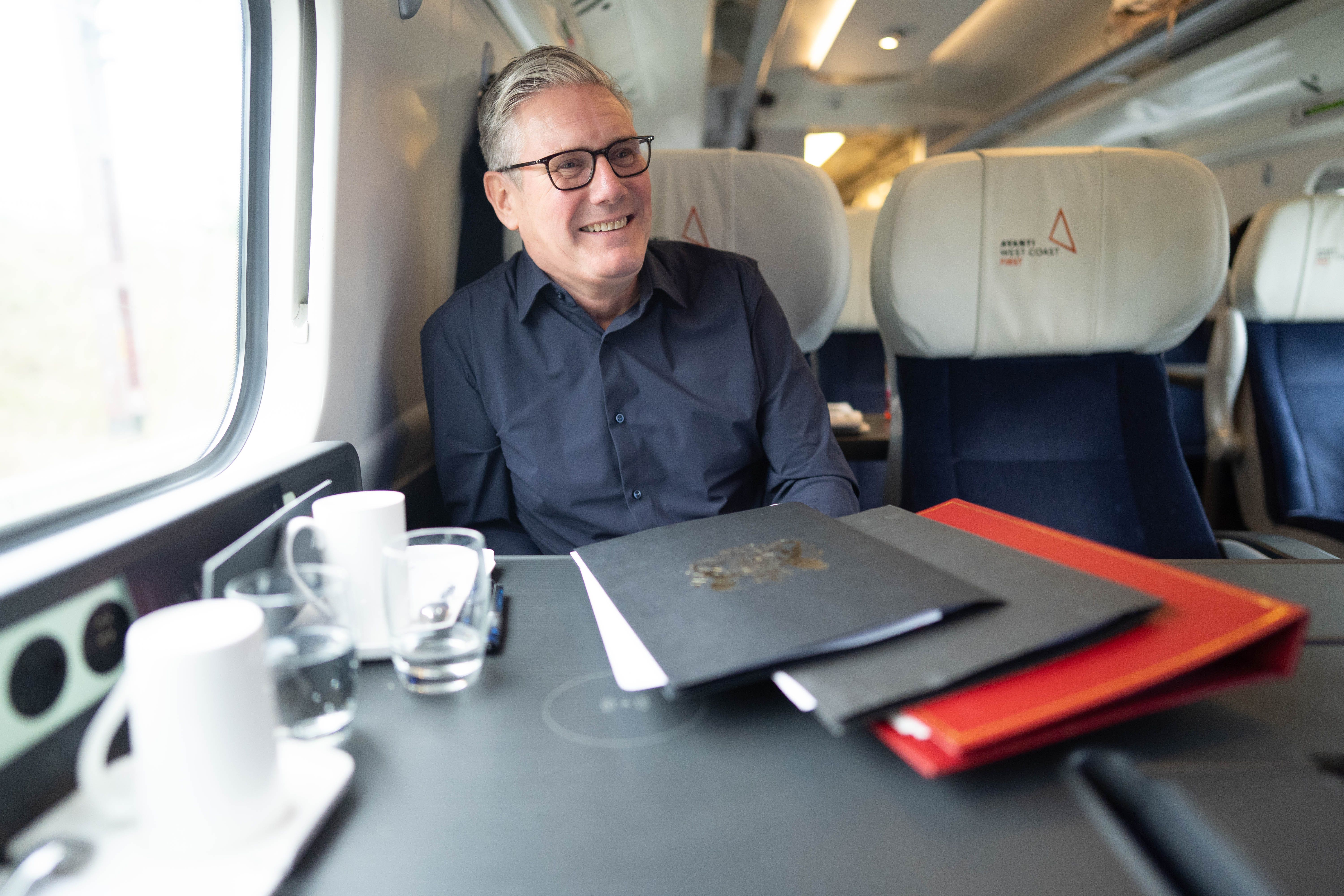 Prime Minister Sir Keir Starmer travelling by train to the Labour Party conference in Liverpool (Stefan Rousseau/PA)