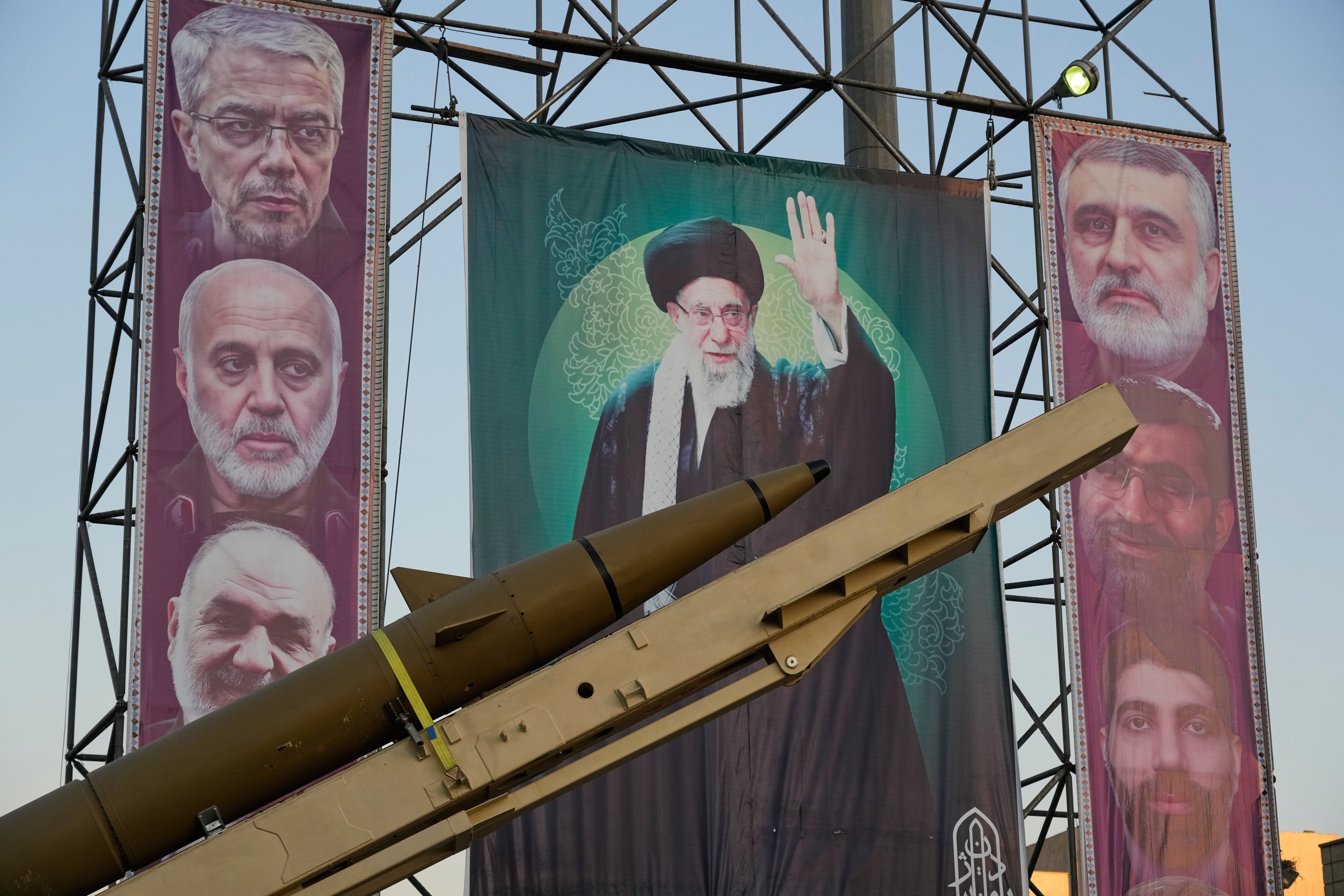 A domestically-built missile ‘Khaibar-buster’ and banners showing portraits of the Iranian Supreme Leader Ayatollah Ali Khamenei, center, and the late armed forces commanders, who were killed in an Israeli strike in June