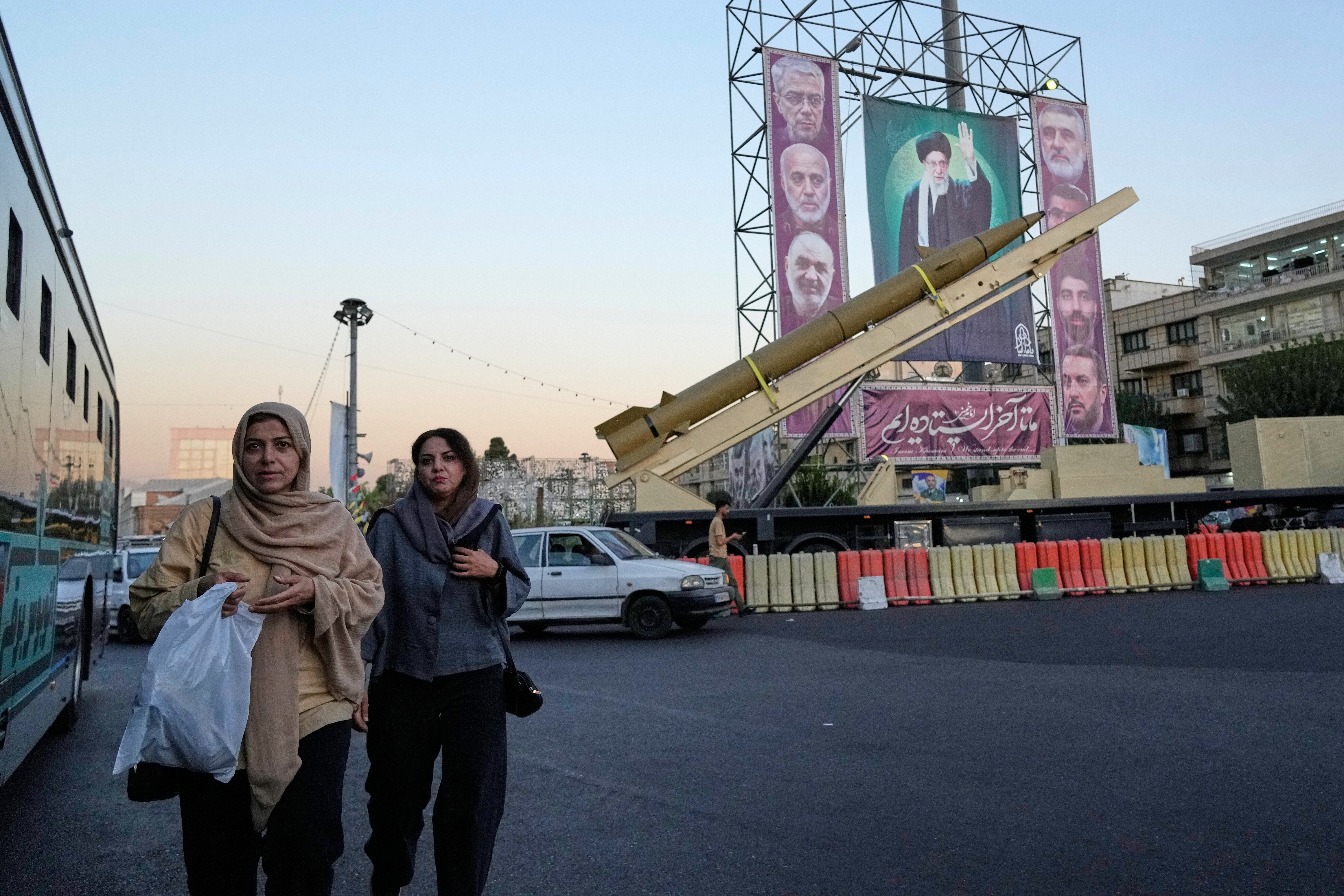 Iranian women walk past an exhibition showing a ballistic missile and portraits of Supreme Leader Ayatollah Ali Khamenei and armed forces commanders killed in Israel’s war in June at Baharestan Square in Tehran, on 25 September 2025