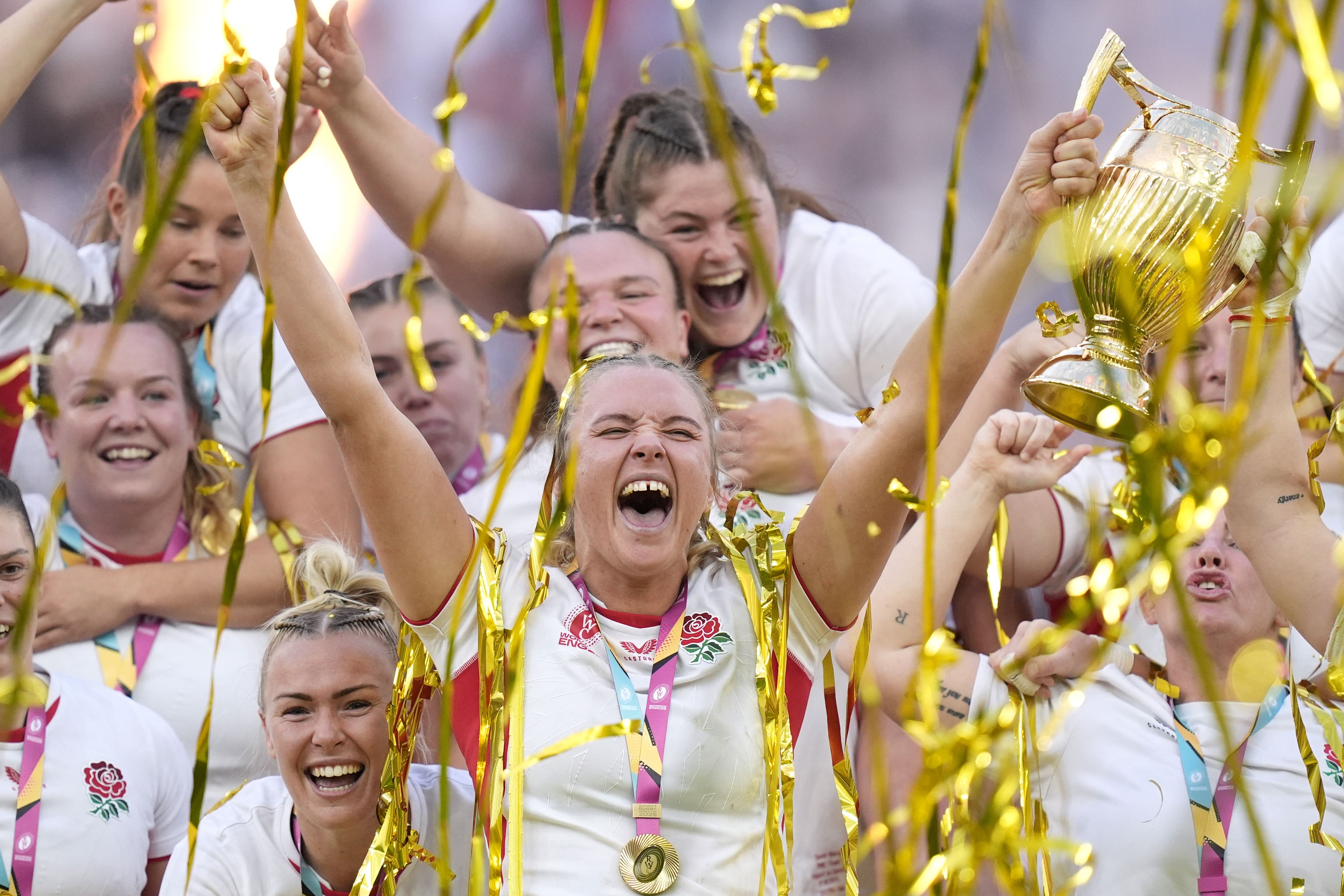 England’s players celebrate as Zoe Aldcroft lifts the Women’s Rugby World trophy (Andrew Matthews/PA)
