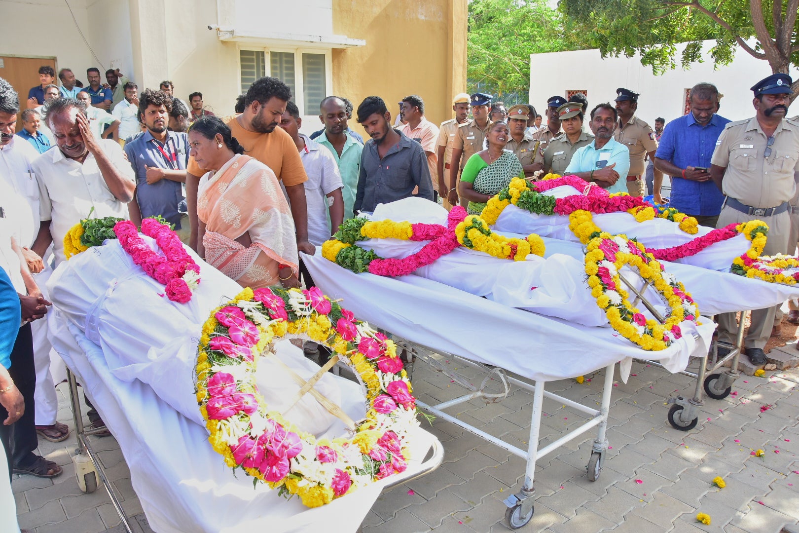 Relatives of people killed in the Karur stampede mourn as they take the bodies from a hospital