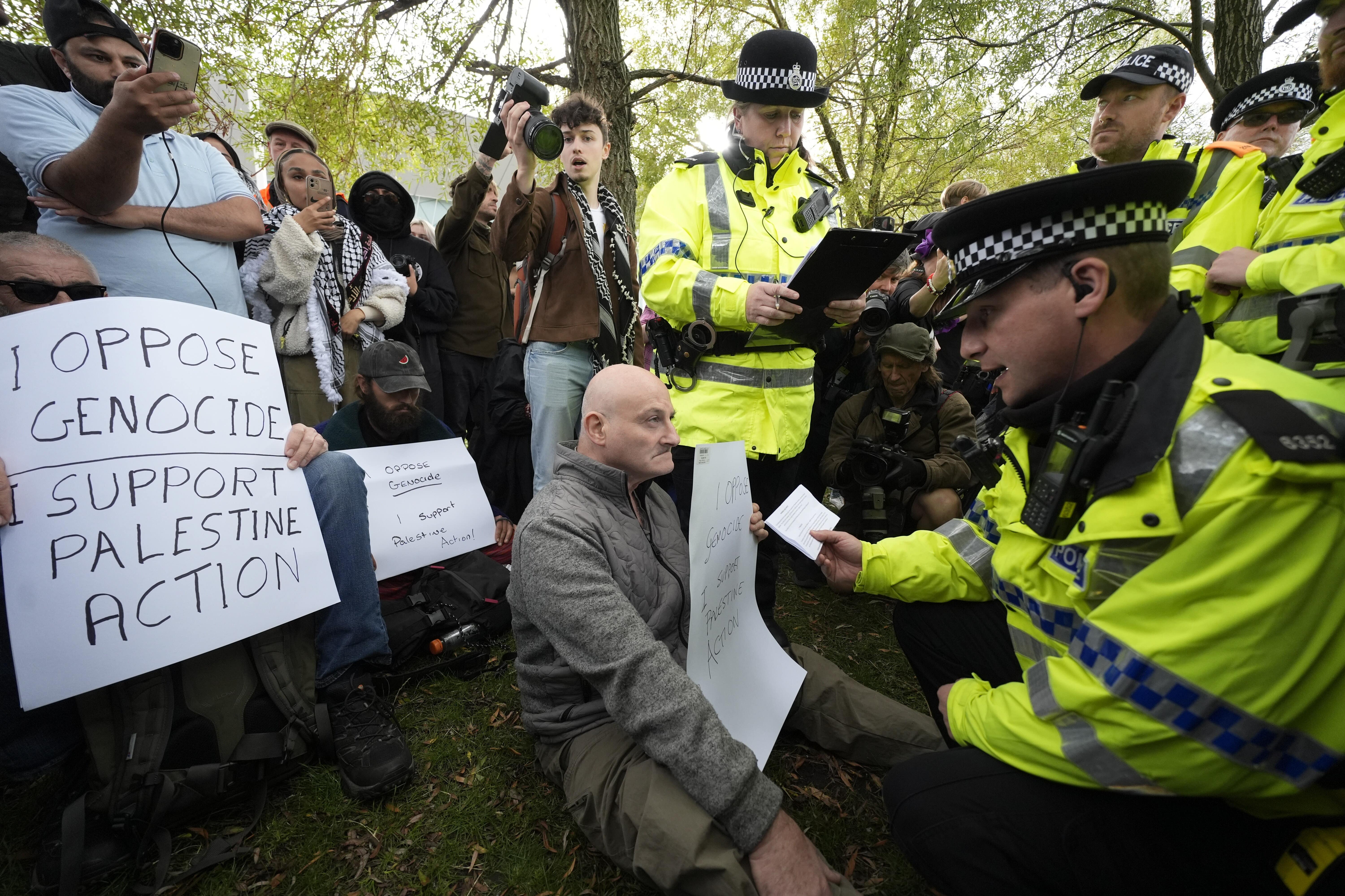 A demonstrator is read his rights by police at a Palestine Action protest outside the Labour Party conference in Liverpool
