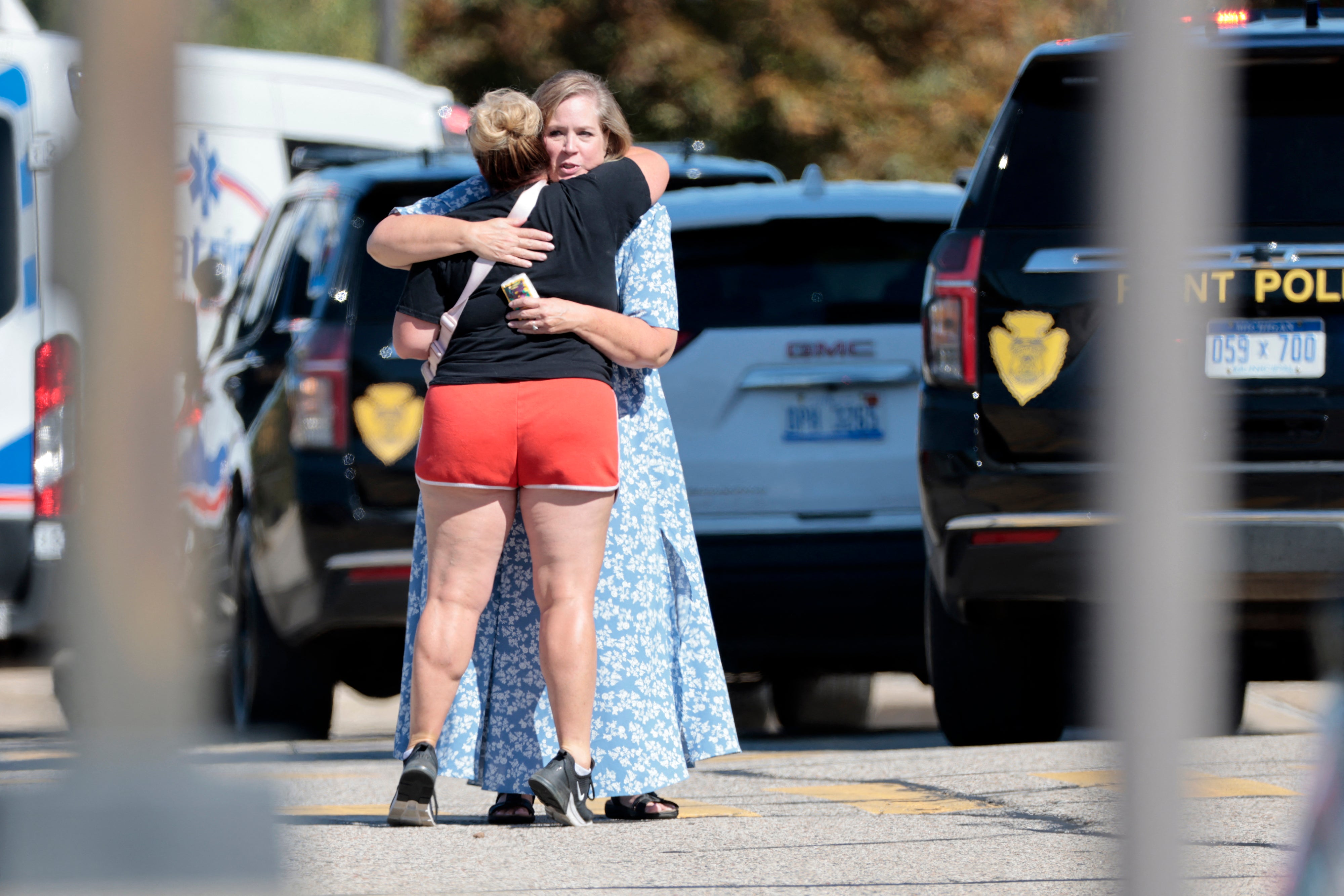People embrace near the scene of a shooting at a church in Grand Blanc, Michigan, on September 28