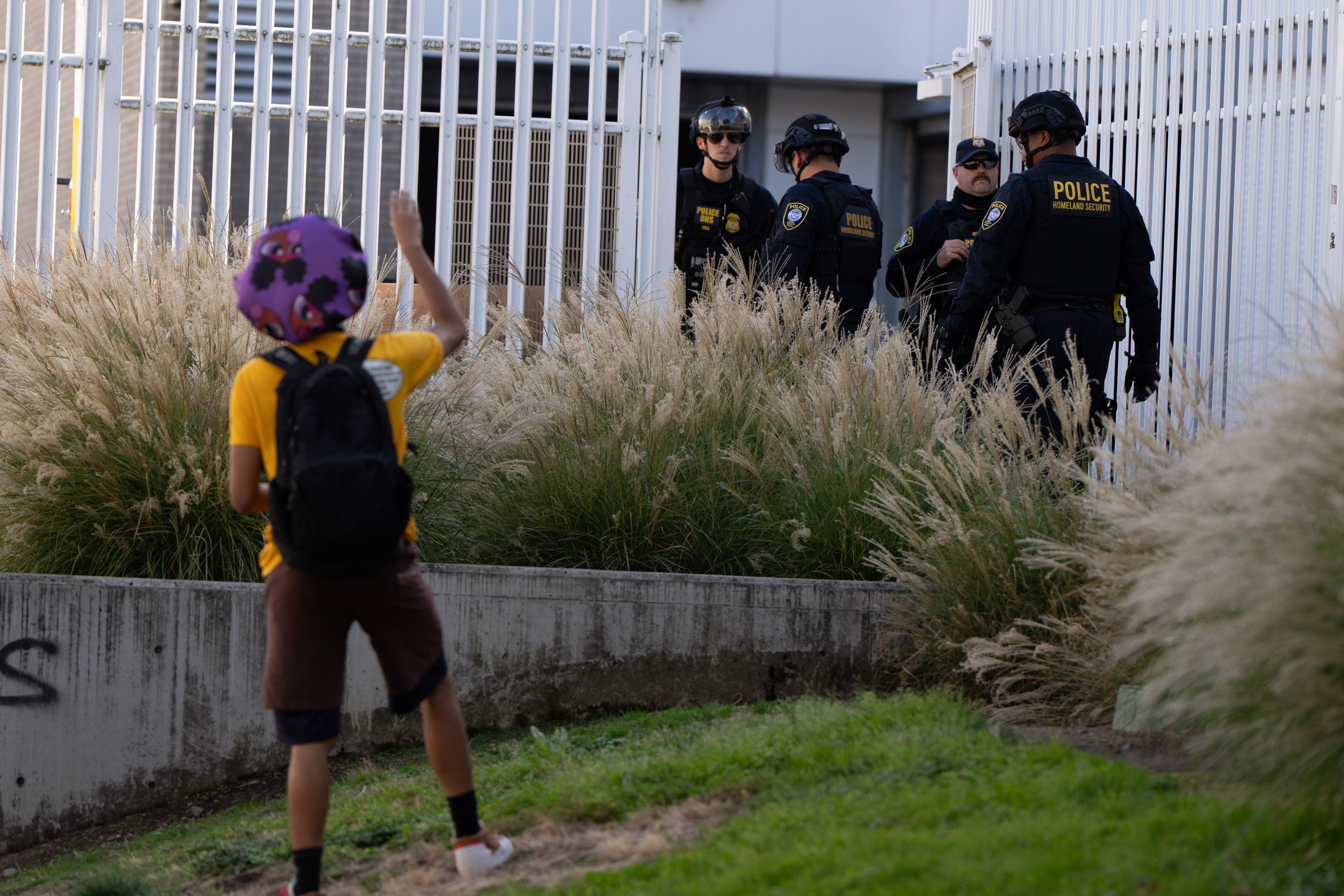 A protestor waves at federal agents outside an ICE facility in Portland, Oregon.