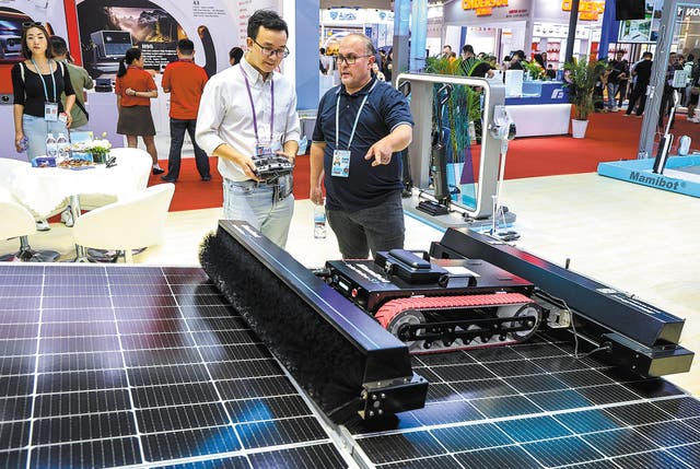 <p>A visitor enquires about a robot that cleans photovoltaic panels during the 136th Canton Fair in Guangzhou, Guangdong province</p>