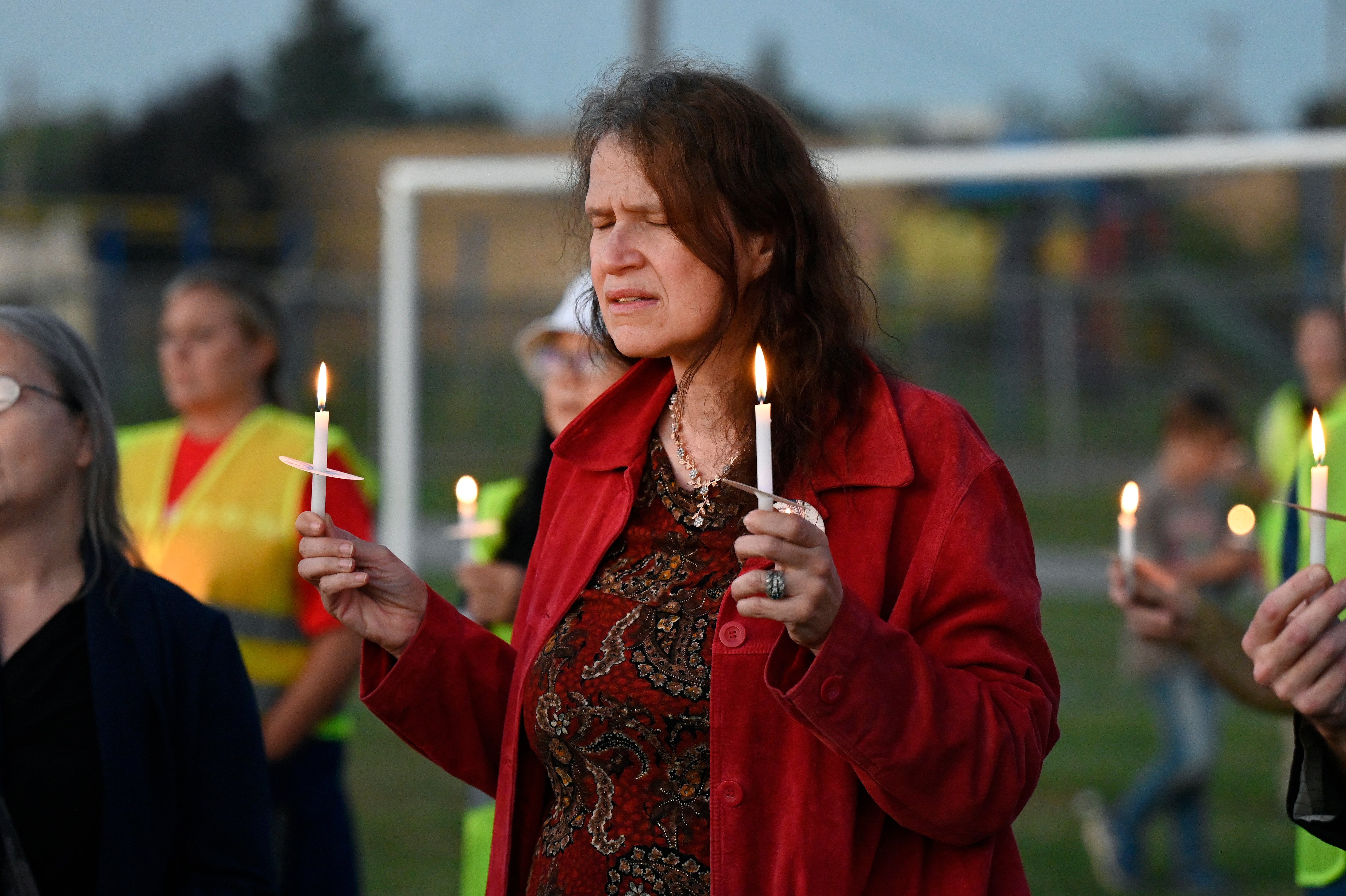 Attendees hold candles at a vigil for the victims of the shooting at the Church of Jesus Christ of Latter-day Saints in Grand Blanc Township, Michigan