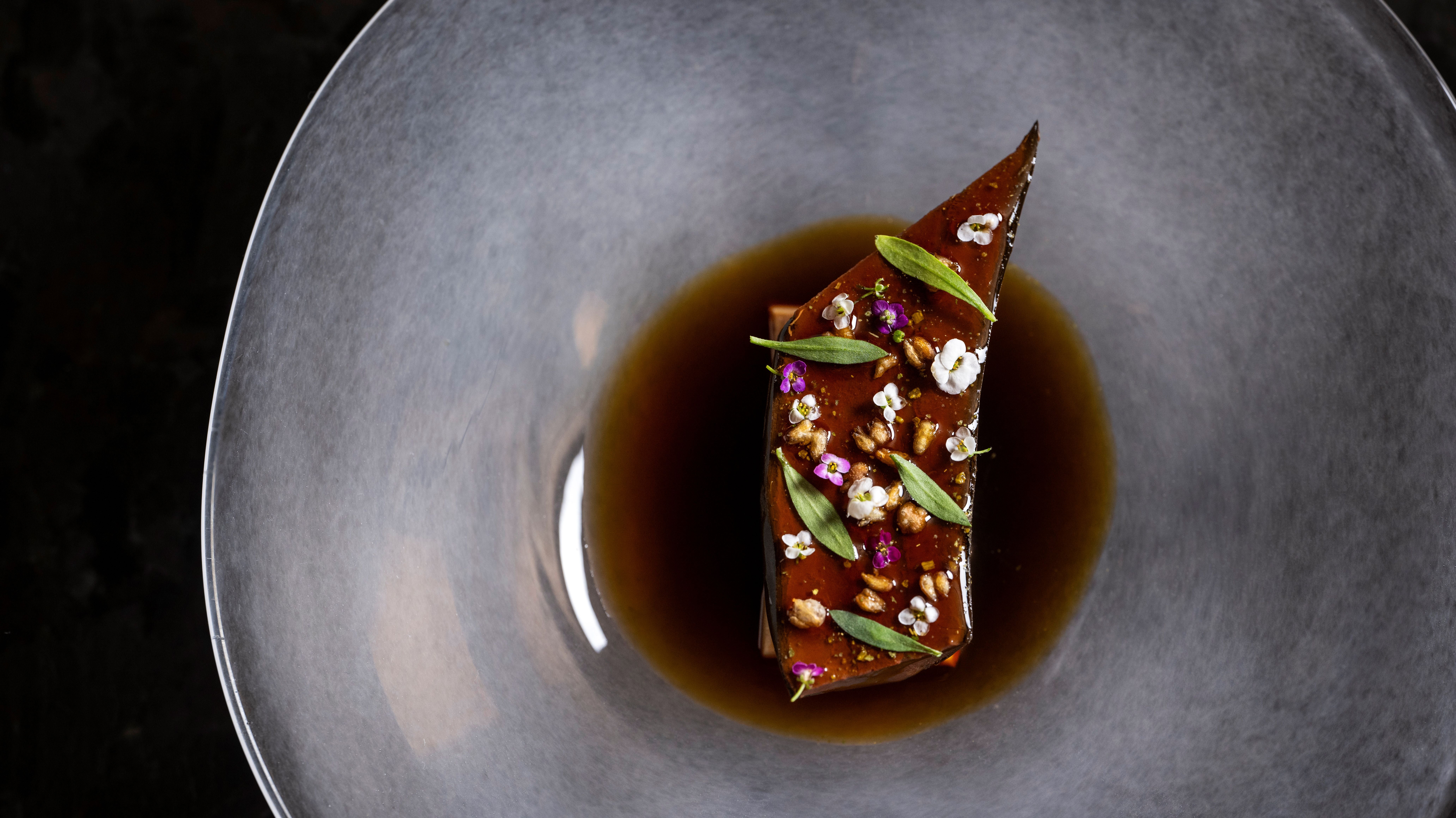 This shows one of the creations served to guests at Atomix – blackened banana with monkfish liver