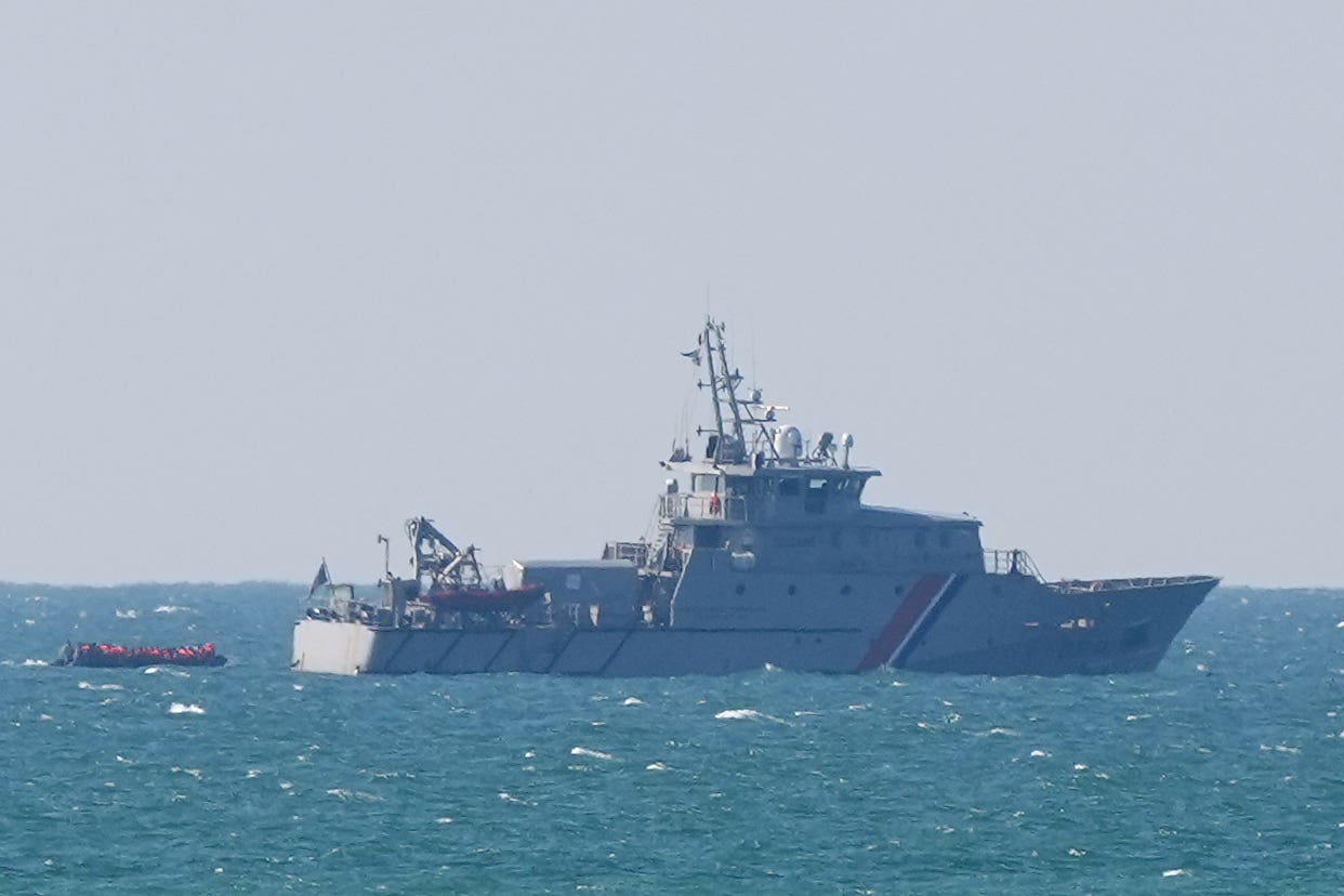 A small boat carrying people thought to be migrants is escorted by the French authorities as it leaves the coastline near Boulogne (Gareth Fuller/PA)