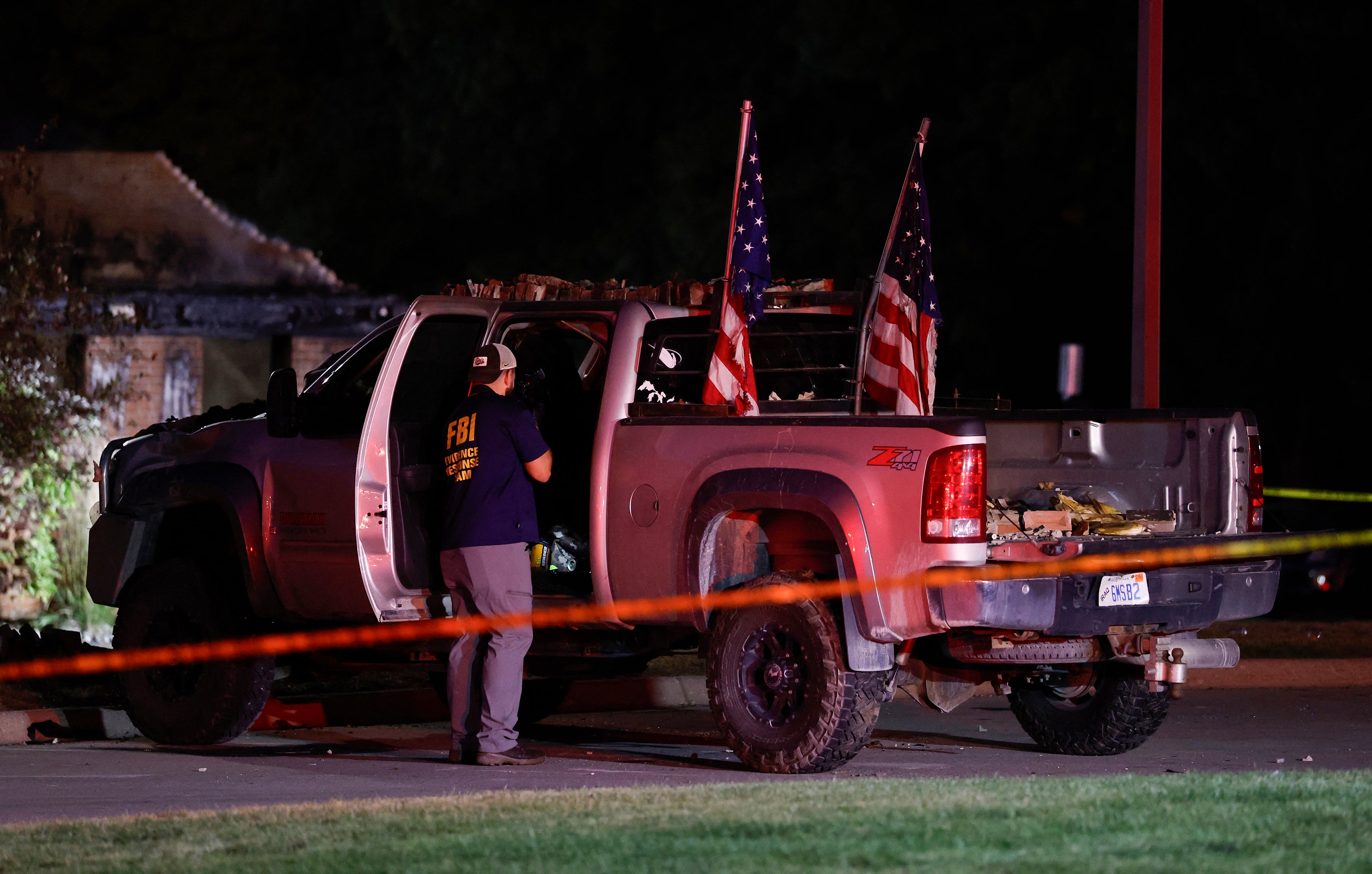 An FBI Evidence Response Team agent inspects the suspect's truck outside the Church of Jesus Christ of Latter Day Saints in Grand Blanc, Michigan