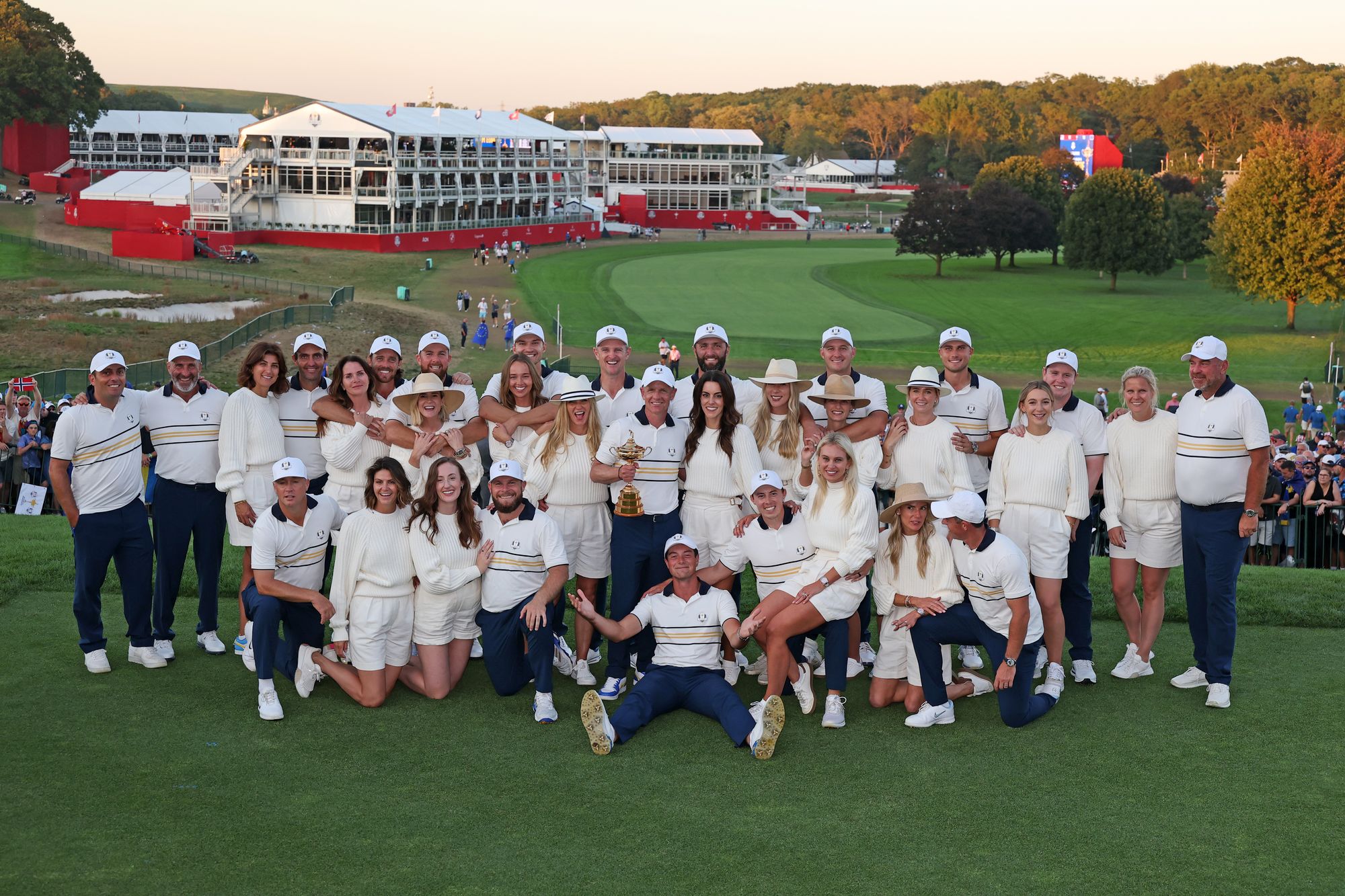 Viktor Hovland sits at the front on his own as wives and partners join the players