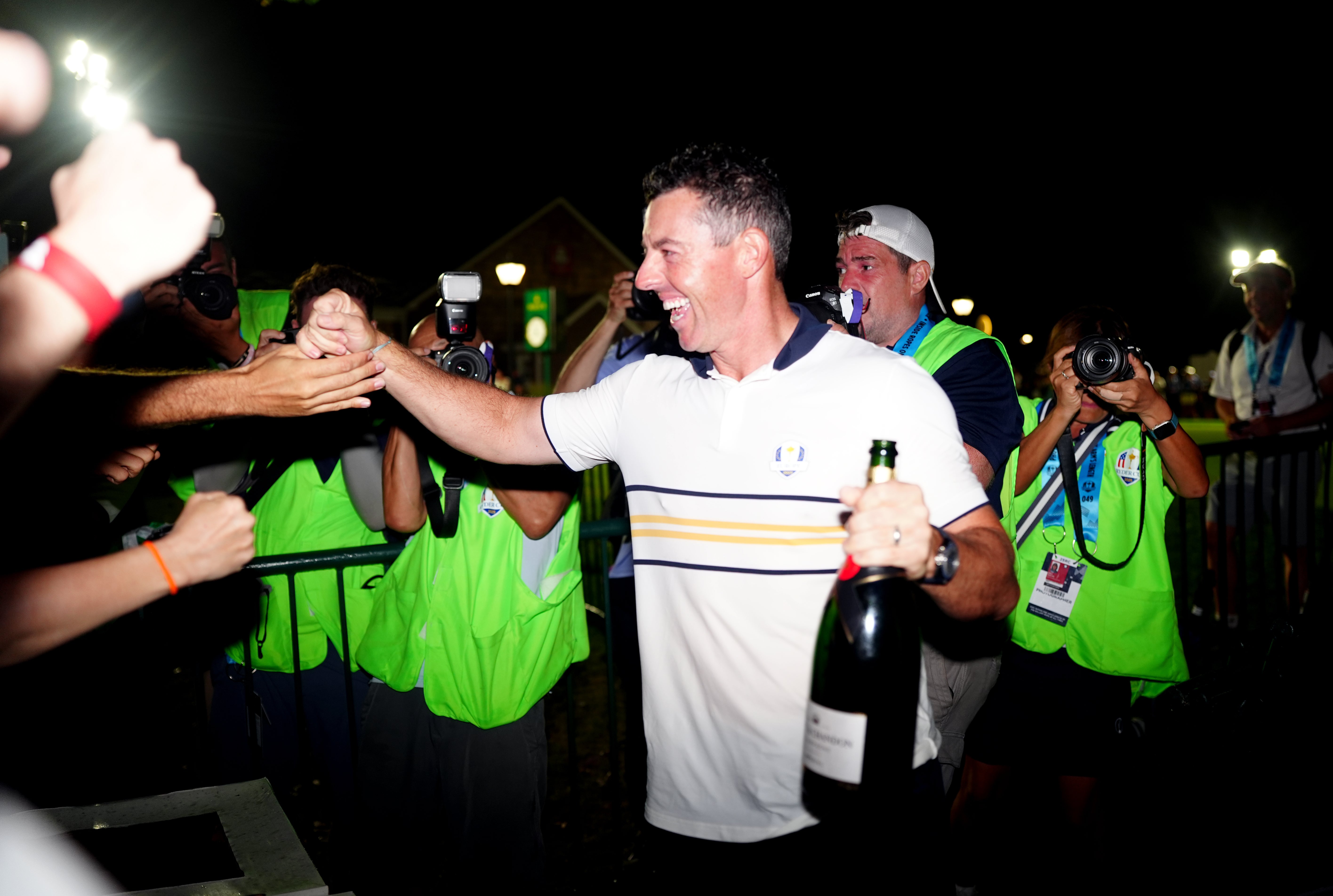 Rory McIlroy high-fives a fan as he celebrates the victory