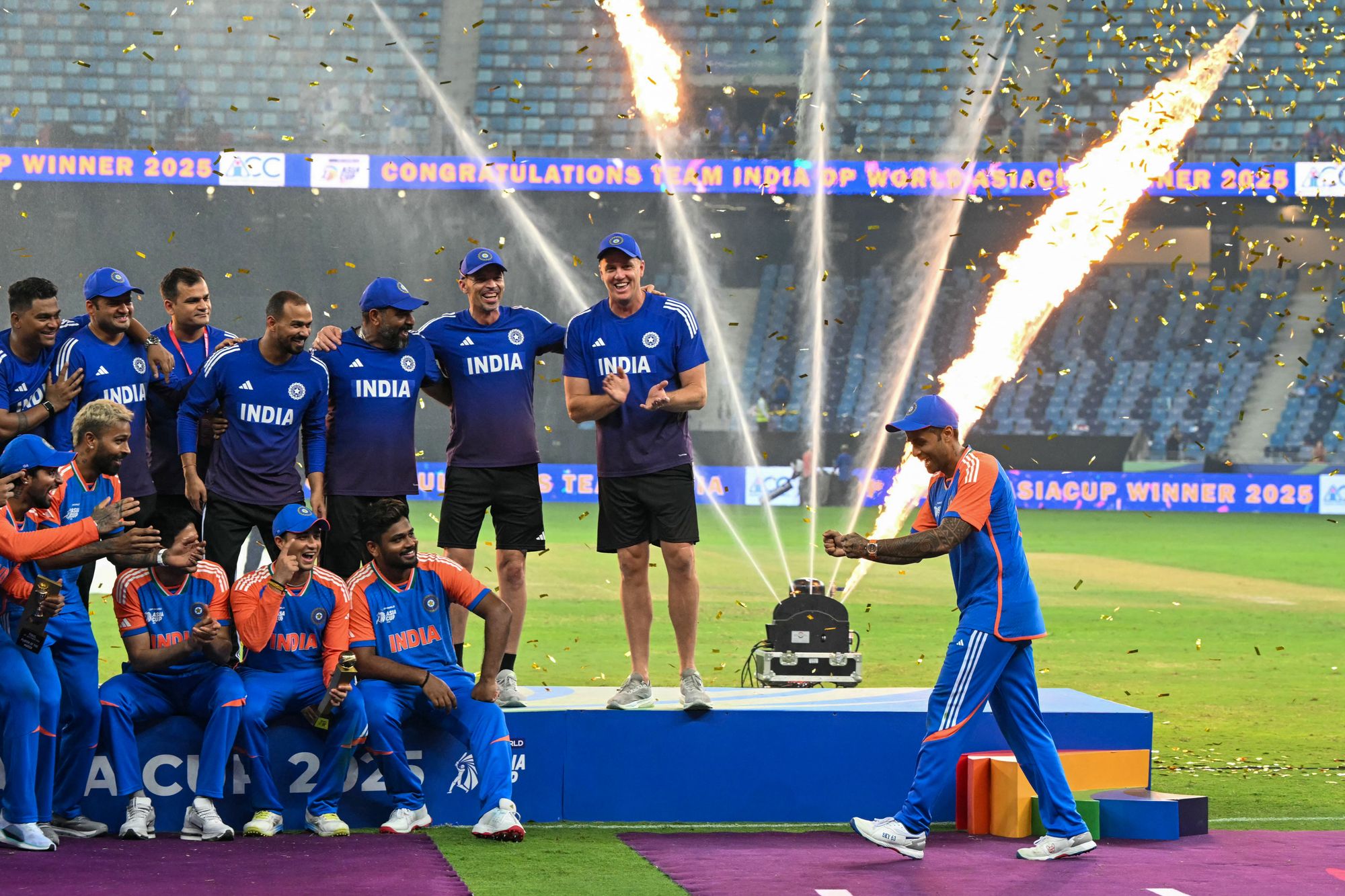 India's captain Suryakumar Yadav, right, pretends to hold the trophy as his team celebrate their Asia Cup victory