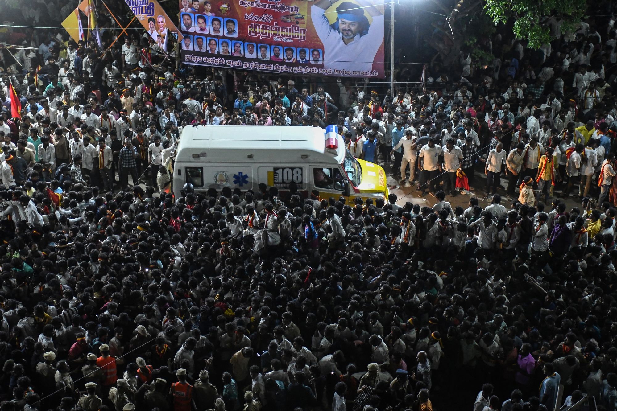 An ambulance carrying victims makes its way through the crowd following the stampede