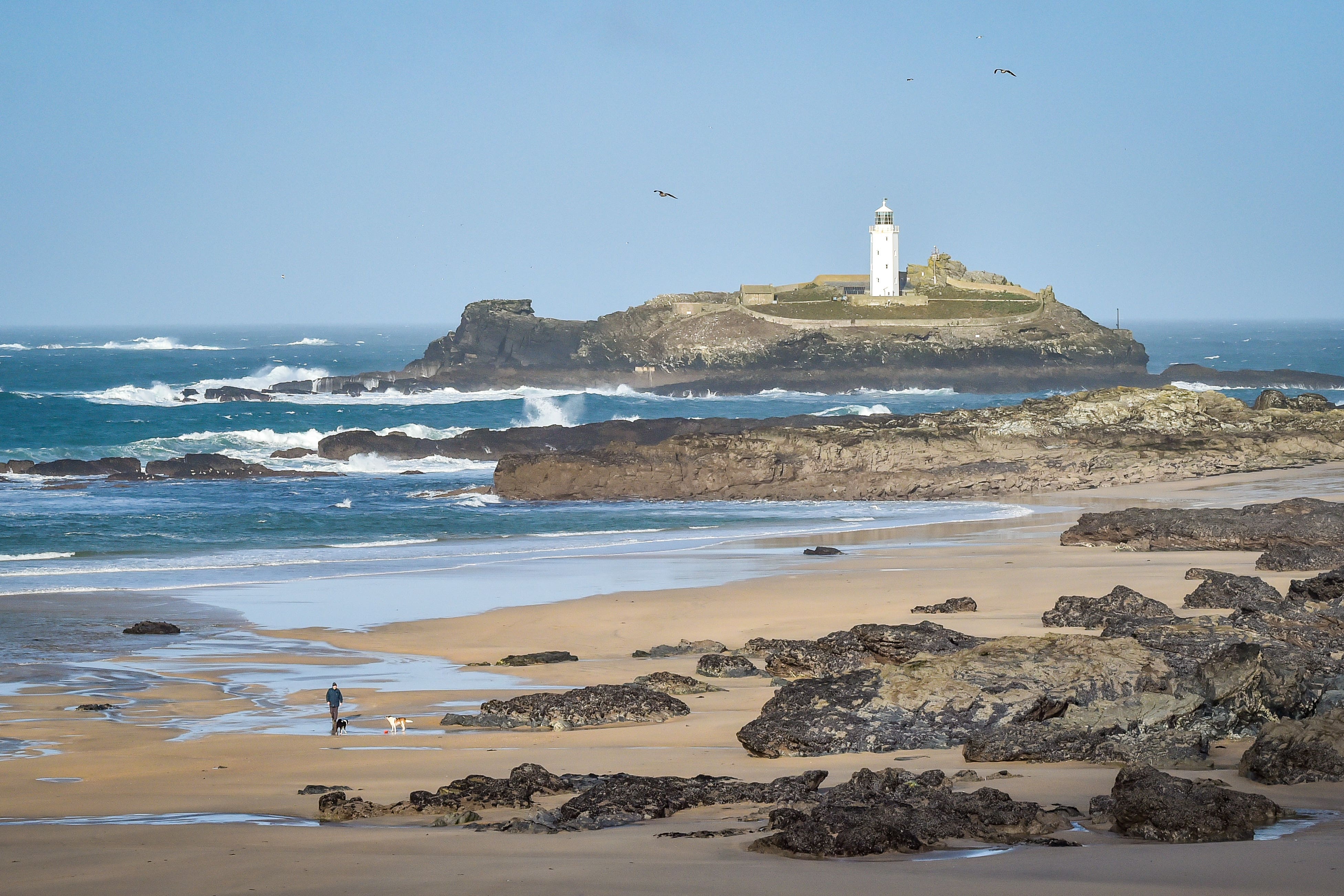 The man was surfing on Gwithian Beach in Cornwall (Ben Birchall/PA)