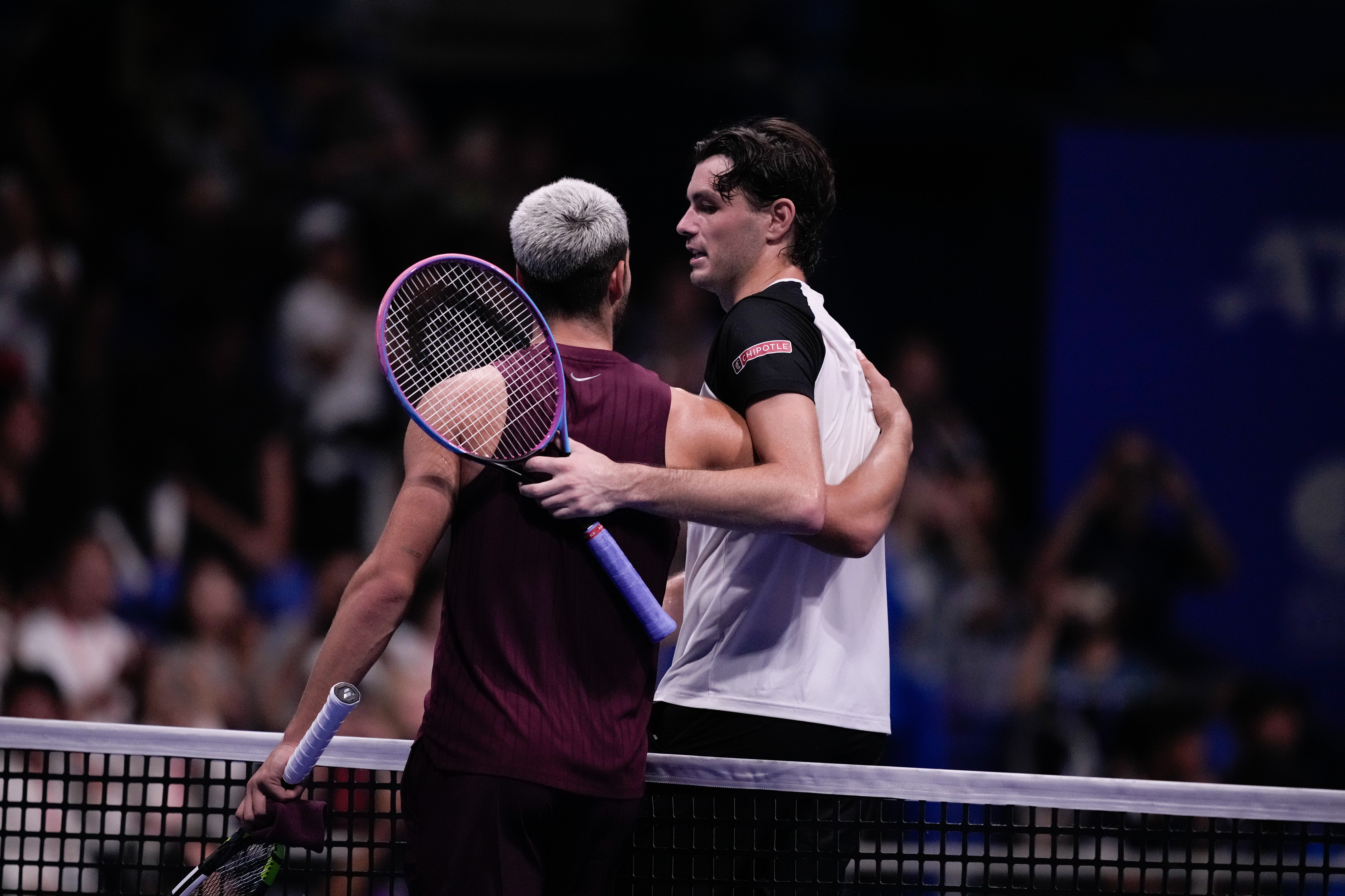 Carlos Alcaraz, left, and Taylor Fritz embrace at the net (Louise Delmotte/AP)