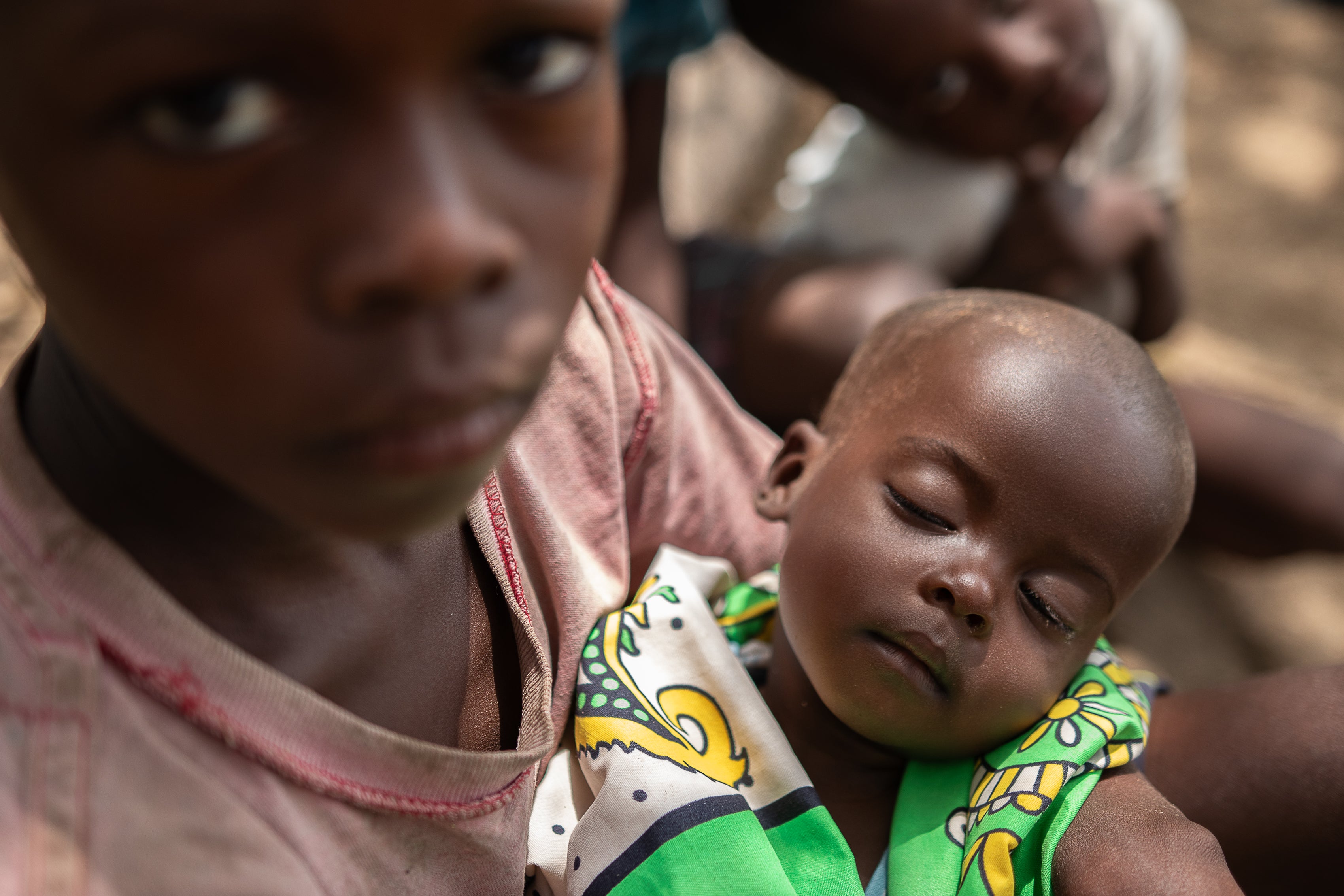 Seven-month old Ekuom, who is mlanourished, is held by his eight-year-old brother Kenya. The family is surviving on one meal a day of plain maize, but there are some days when they cannot afford any food