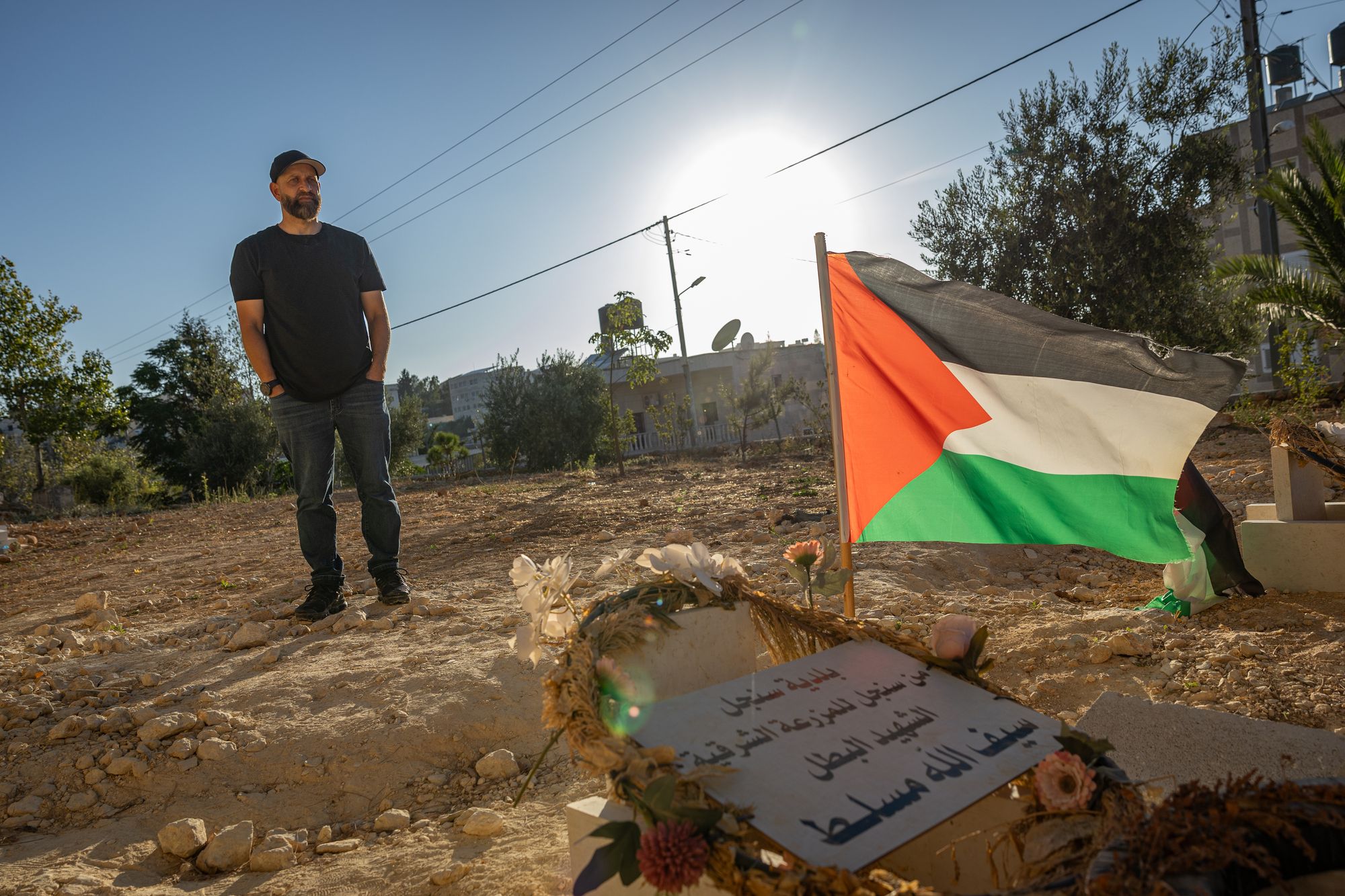 Kamel stands next to his son’s grave after he was beaten to death by settlers in the occupied West Bank