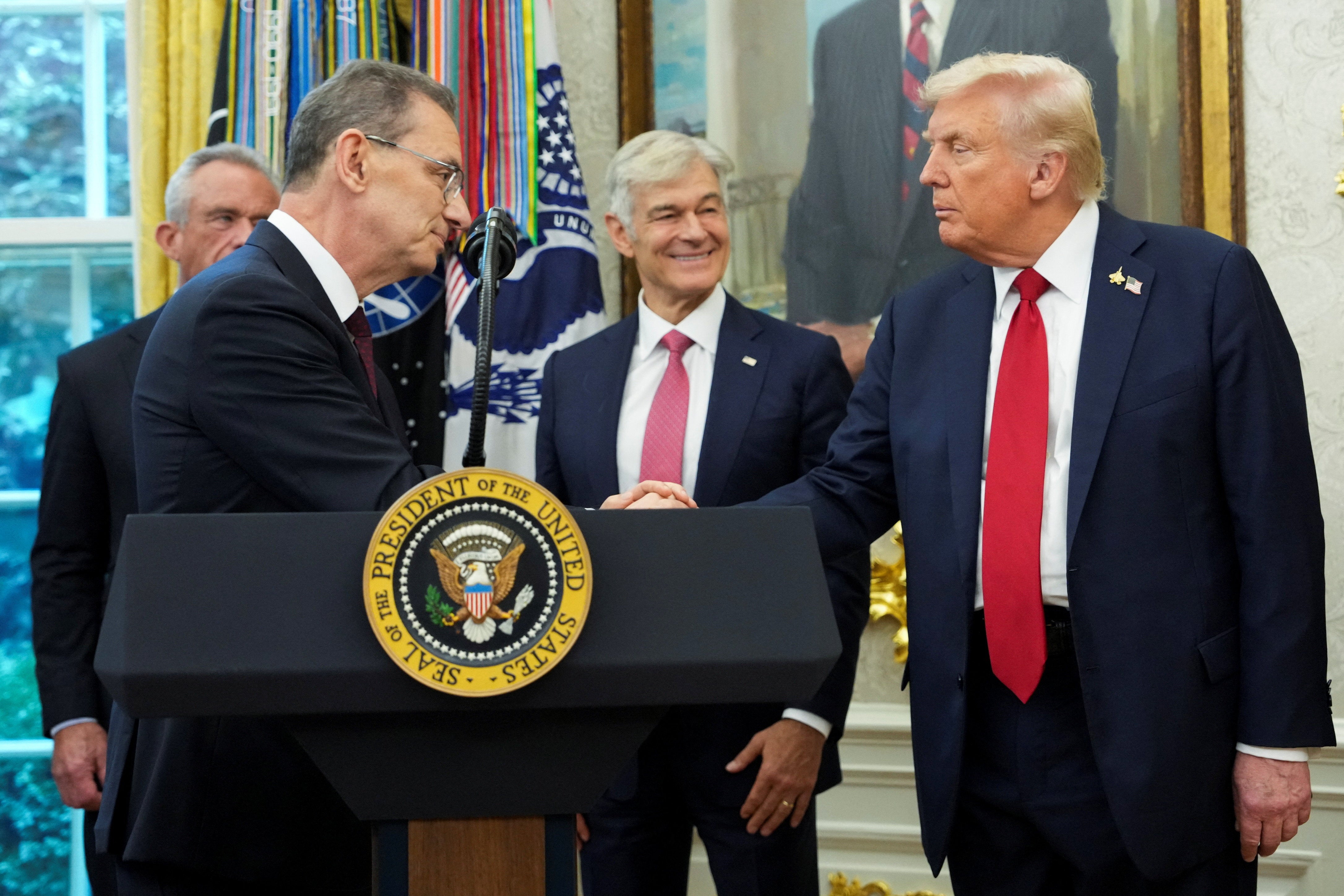 President Donald Trump shakes hands with Pfizer CEO Albert Bourla. Pfizer will now sell drugs to Medicaid at “most-favored-nation” prices, according to a new agreement with the White House