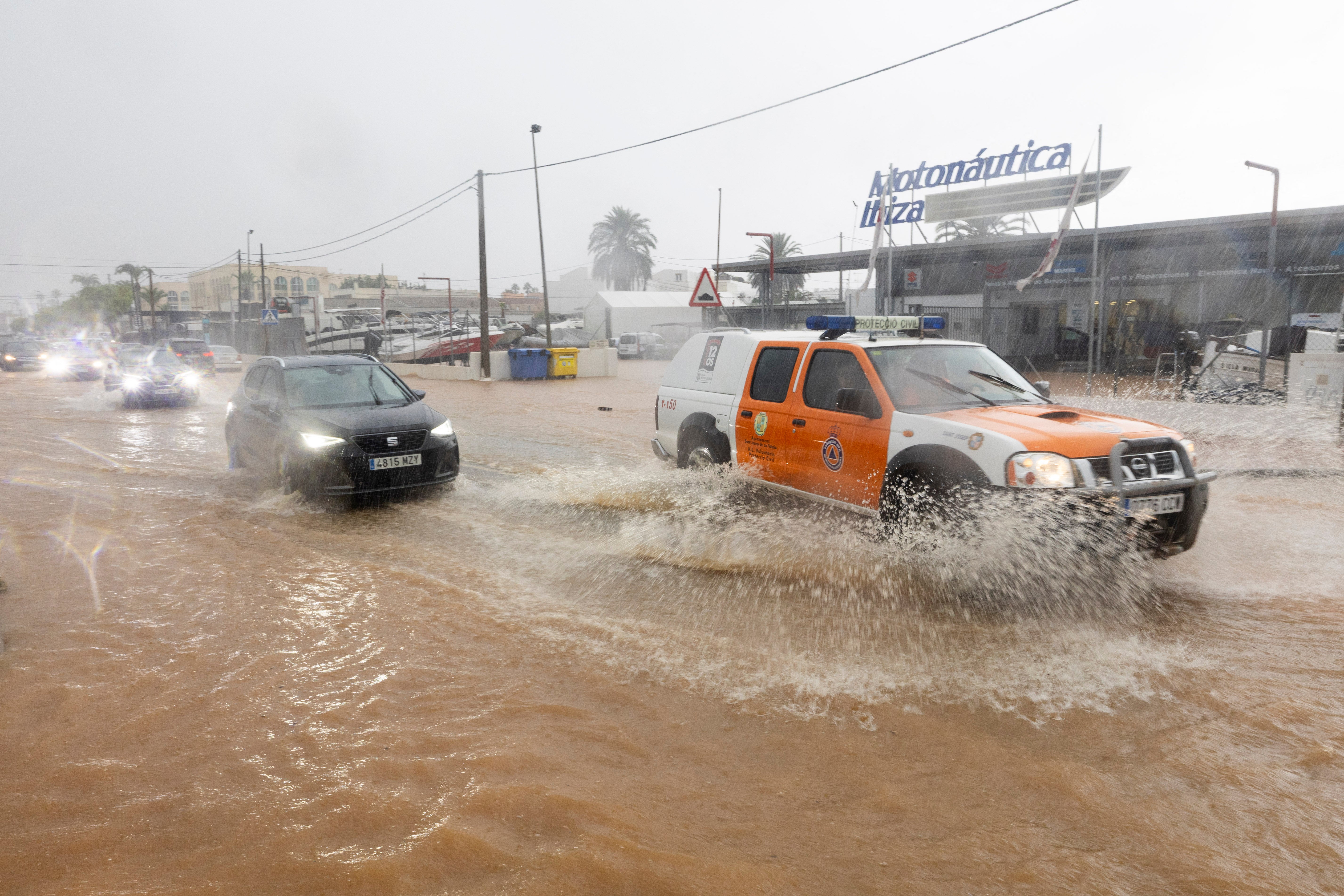 A civil protection vehicle drives through a flooded street in Sant Jordi on the island of Ibiza on September 30, 2025
