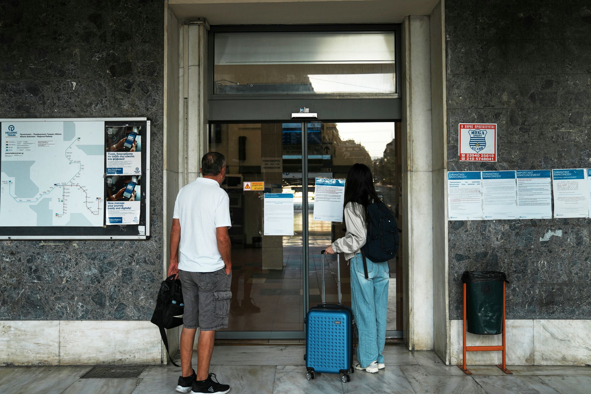 Passengers read an announcement about the nationwide 24-hour strike outside the closed main railway station. (AP Photo/Thanassis Stavrakis)