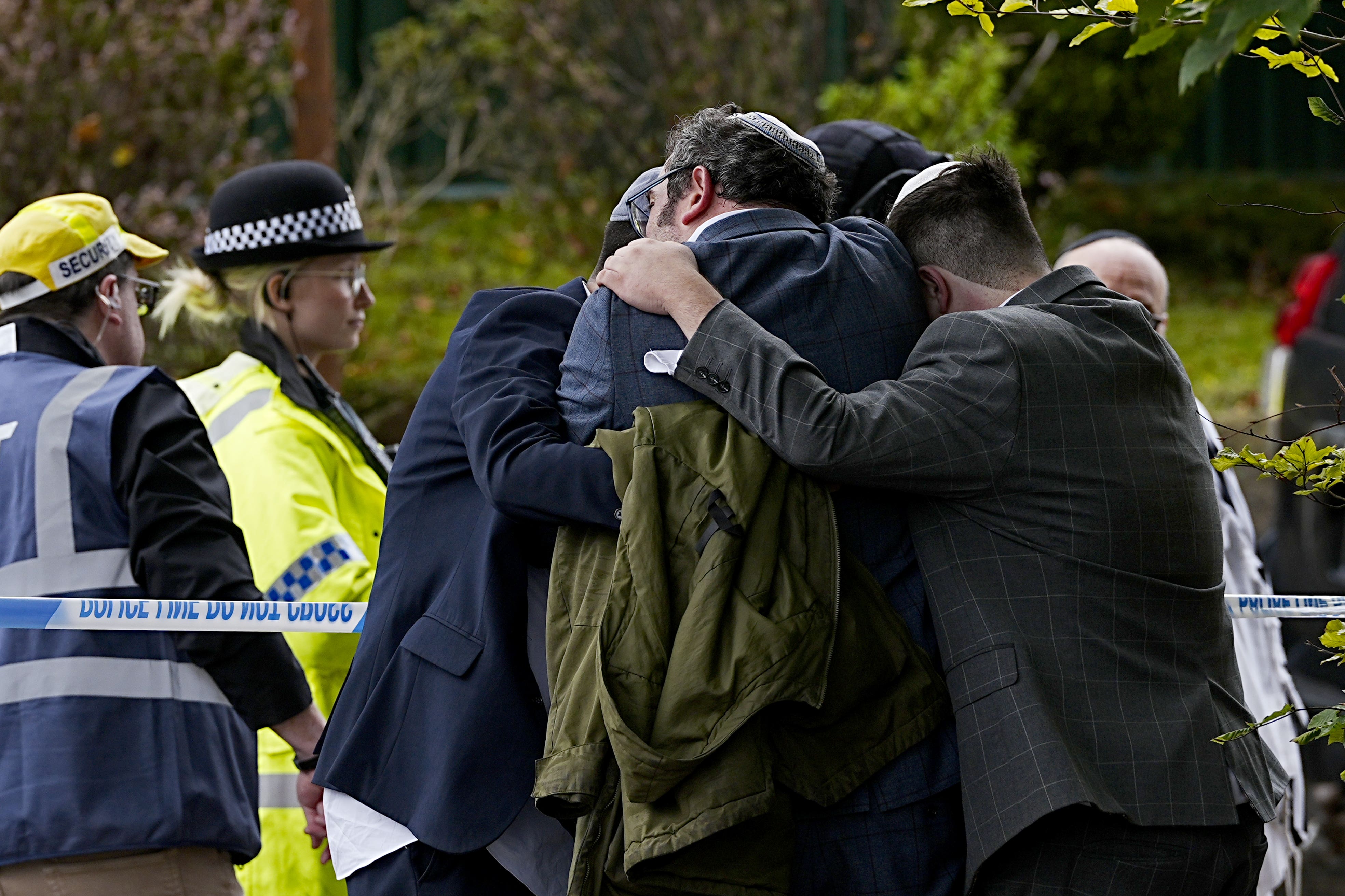 Members of the community embrace near the scene of the attack on Thursday morning