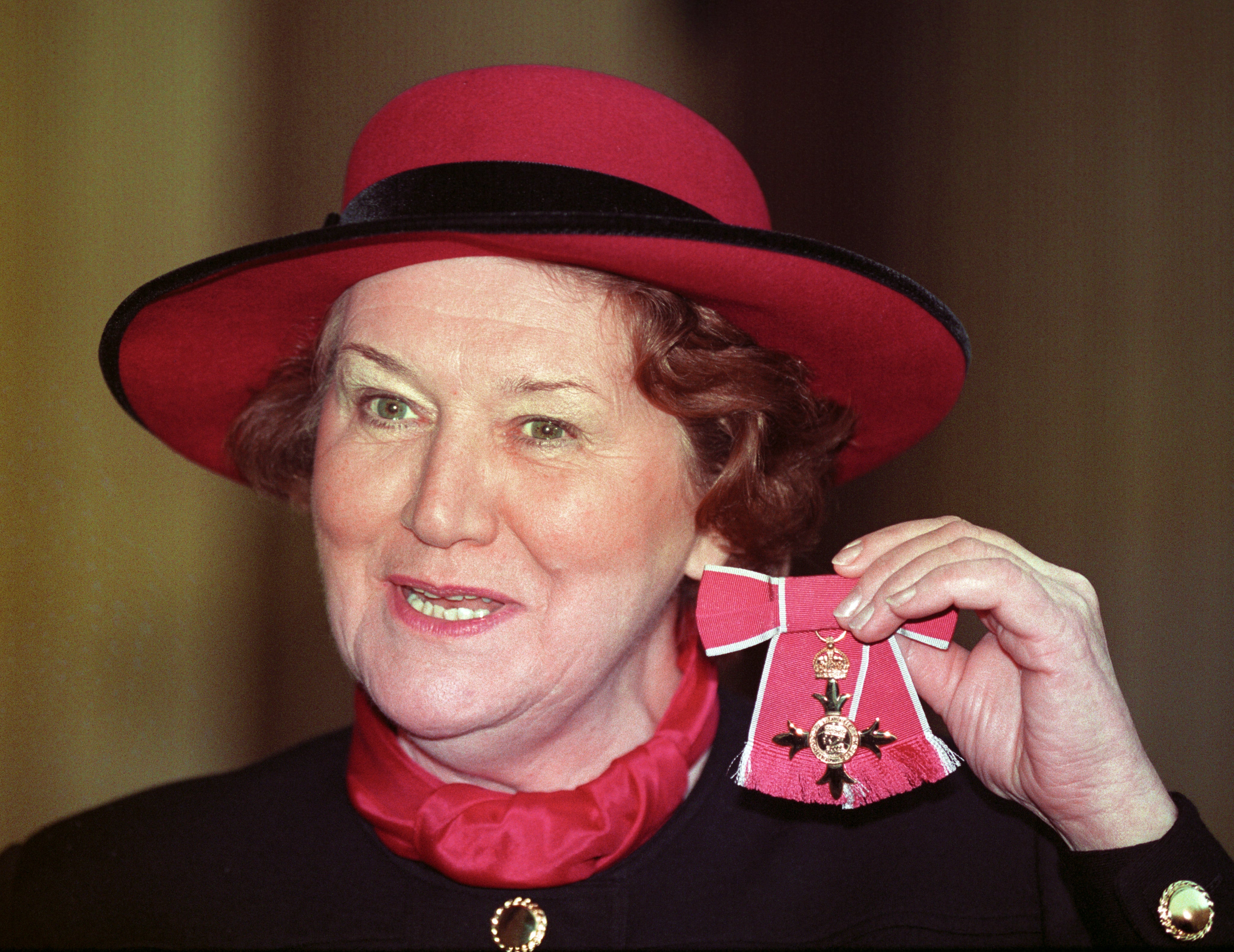 Routledge at Buckingham Palace in 1993 after receiving her OBE from Queen Elizabeth