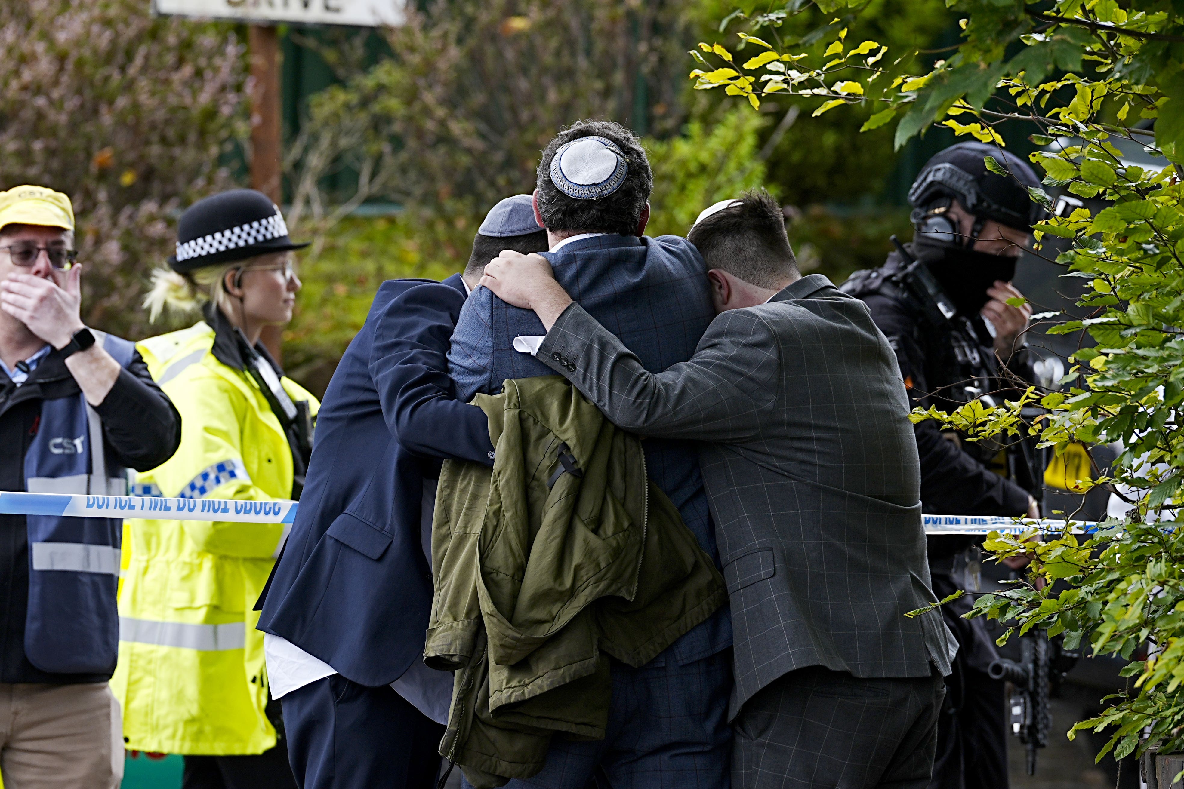 Members of the Jewish community comfort each other (Peter Byrne/PA)