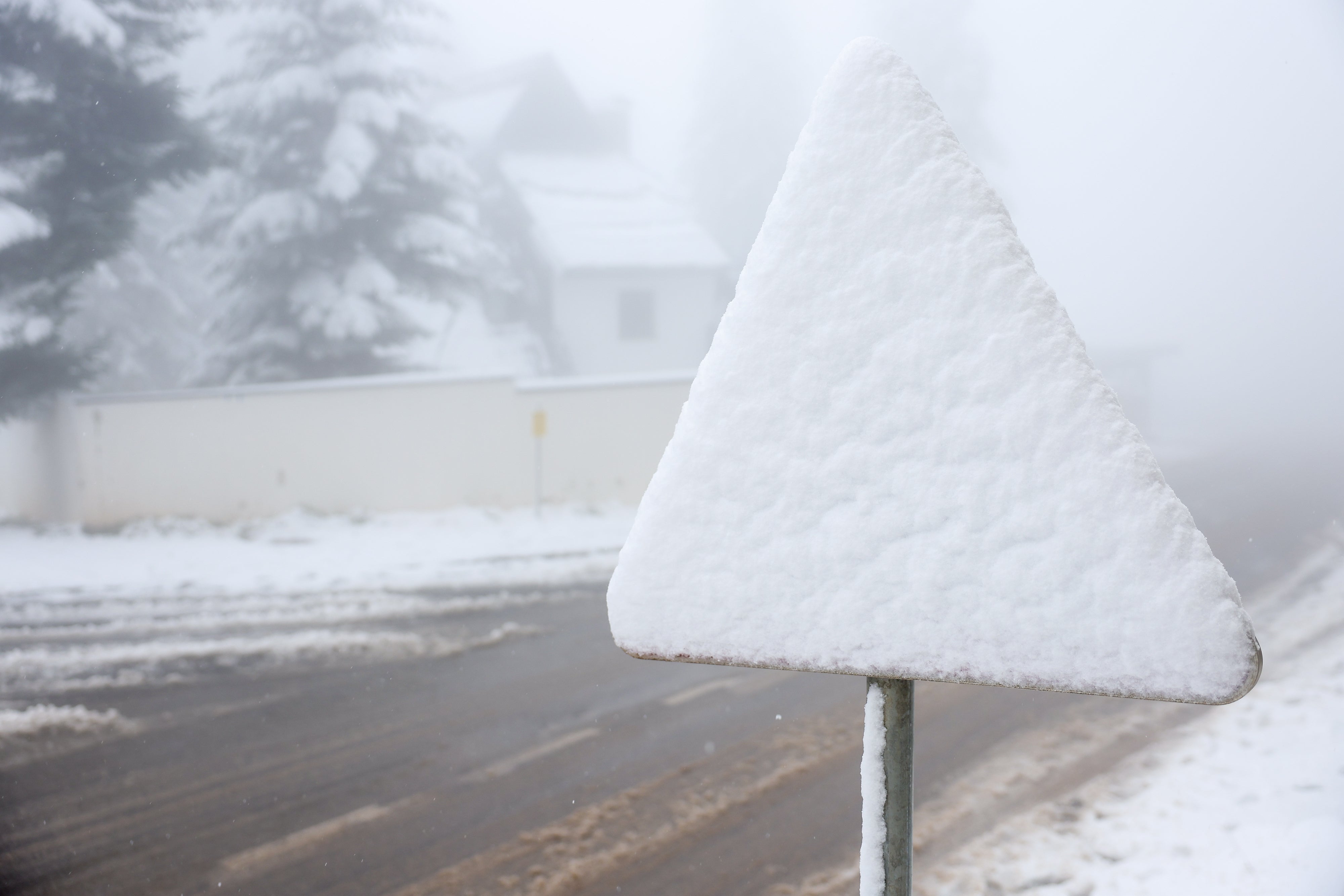 A road sign is covered with snow during an unexpected snowfall on mountain Jahorina near Sarajevo, Bosnia, Thursday, Oct. 2, 2025. (AP Photo/Armin Durgut)