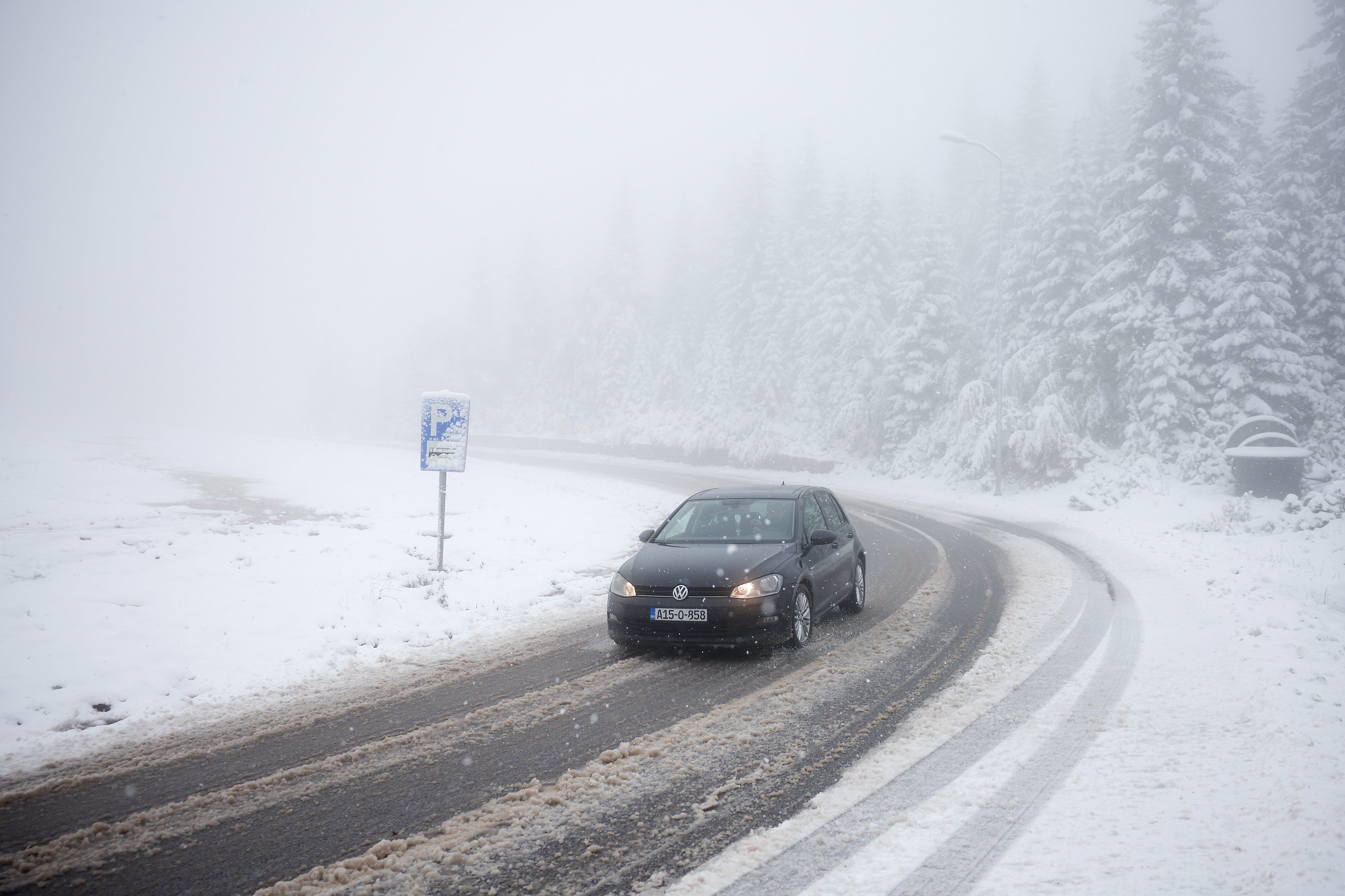 A car drives along a road during an unexpected snowfall on mountain Jahorina near Sarajevo, Bosnia