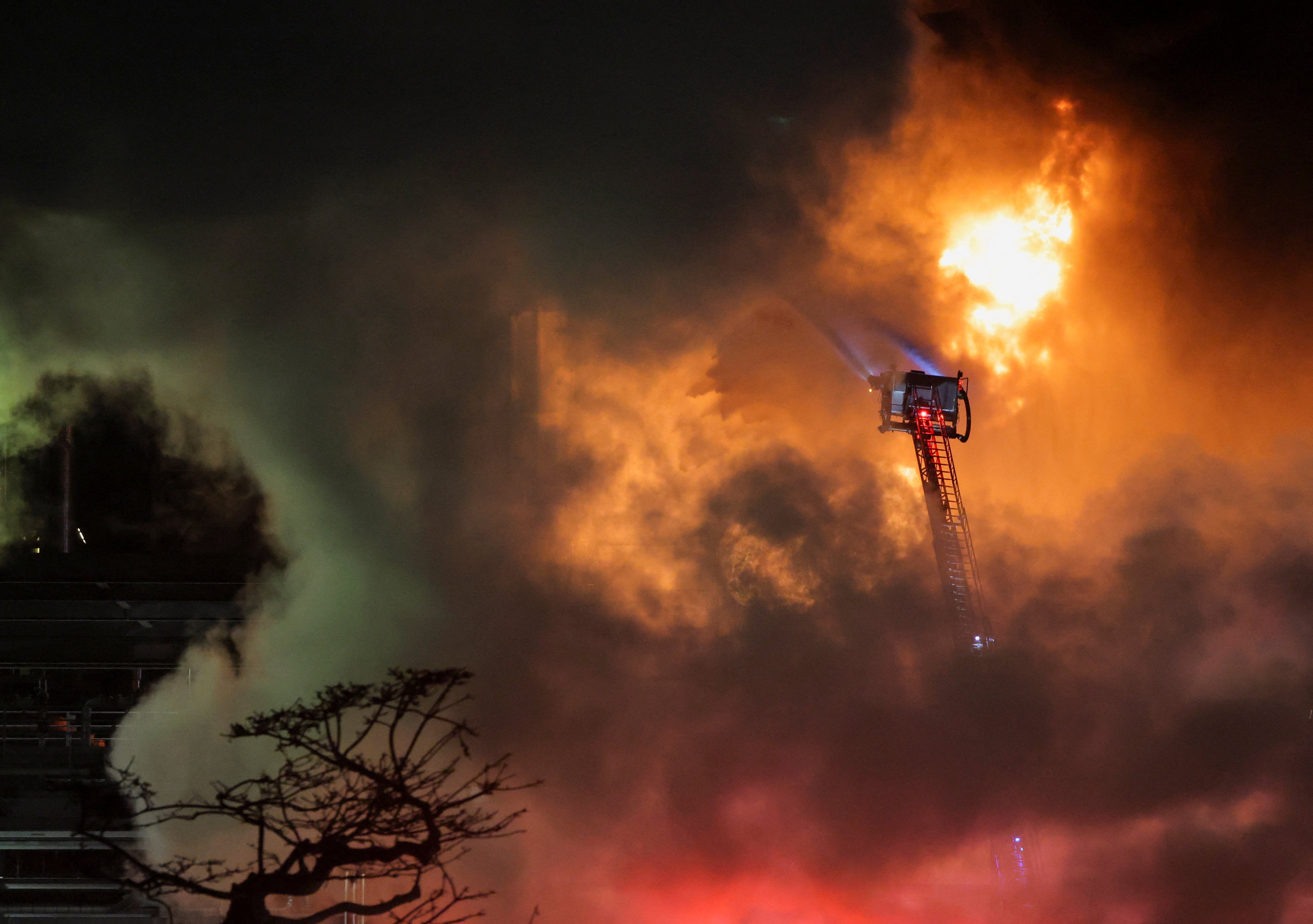 Hoses mounted on the ladder of a firefighting vehicle are used to contain a fire that broke out at the Chevron refinery, in El Segundo, California