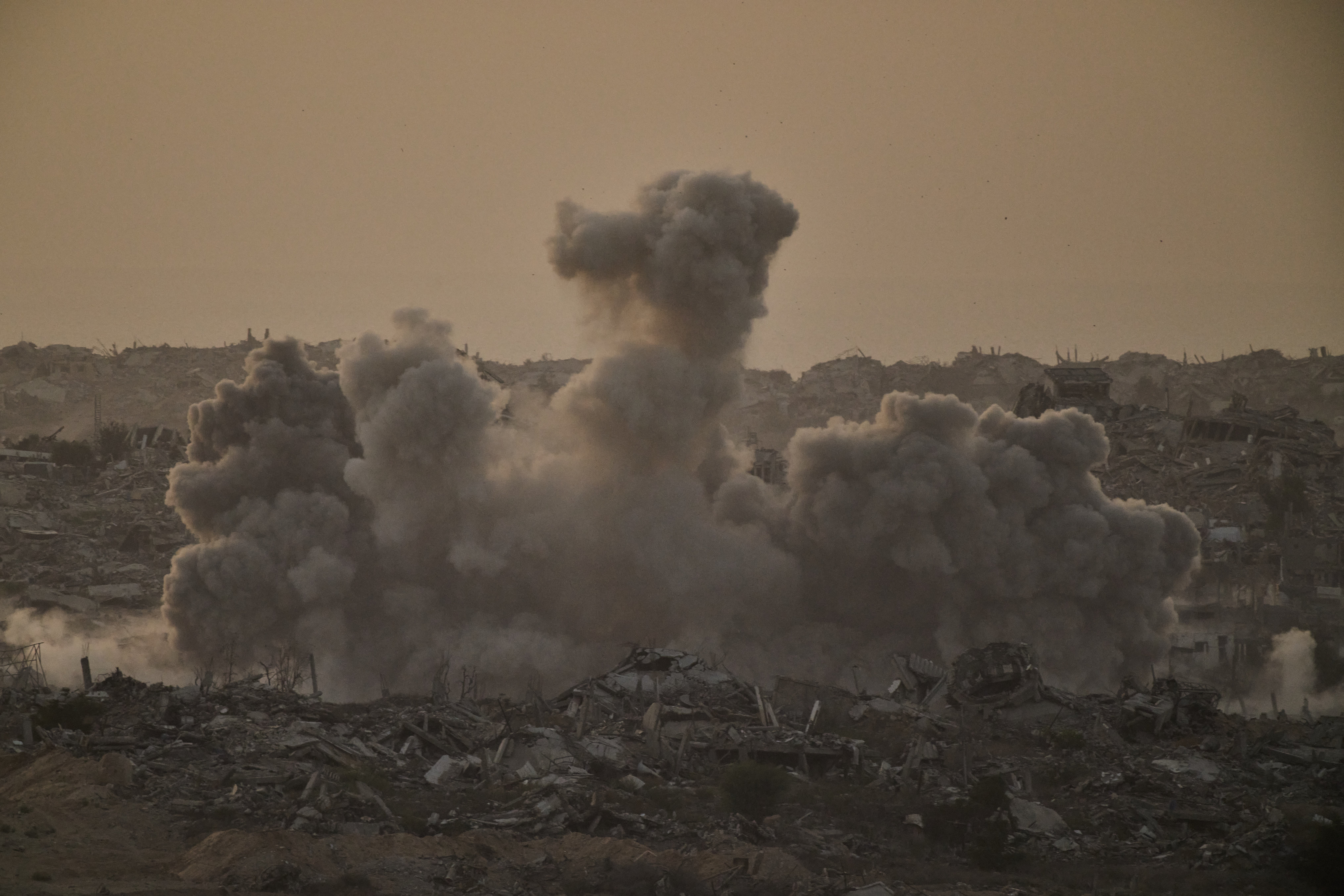 Buildings that were destroyed during the Israeli ground and air operations are engulfed by smoke following an Israeli military strike in the northern Gaza Strip on Friday (Leo Correa/AP)