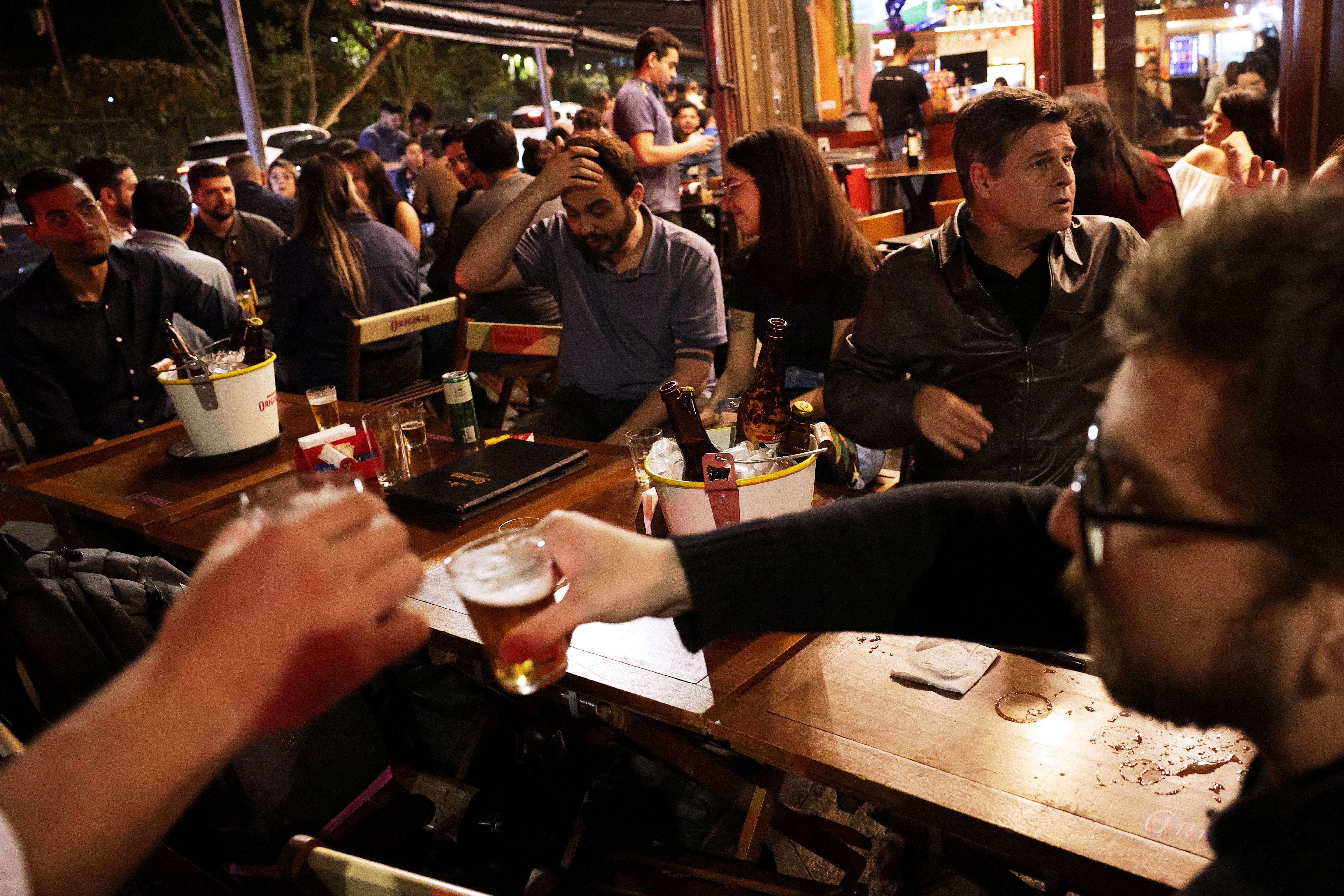 People drink beer at a bar in Sao Paulo