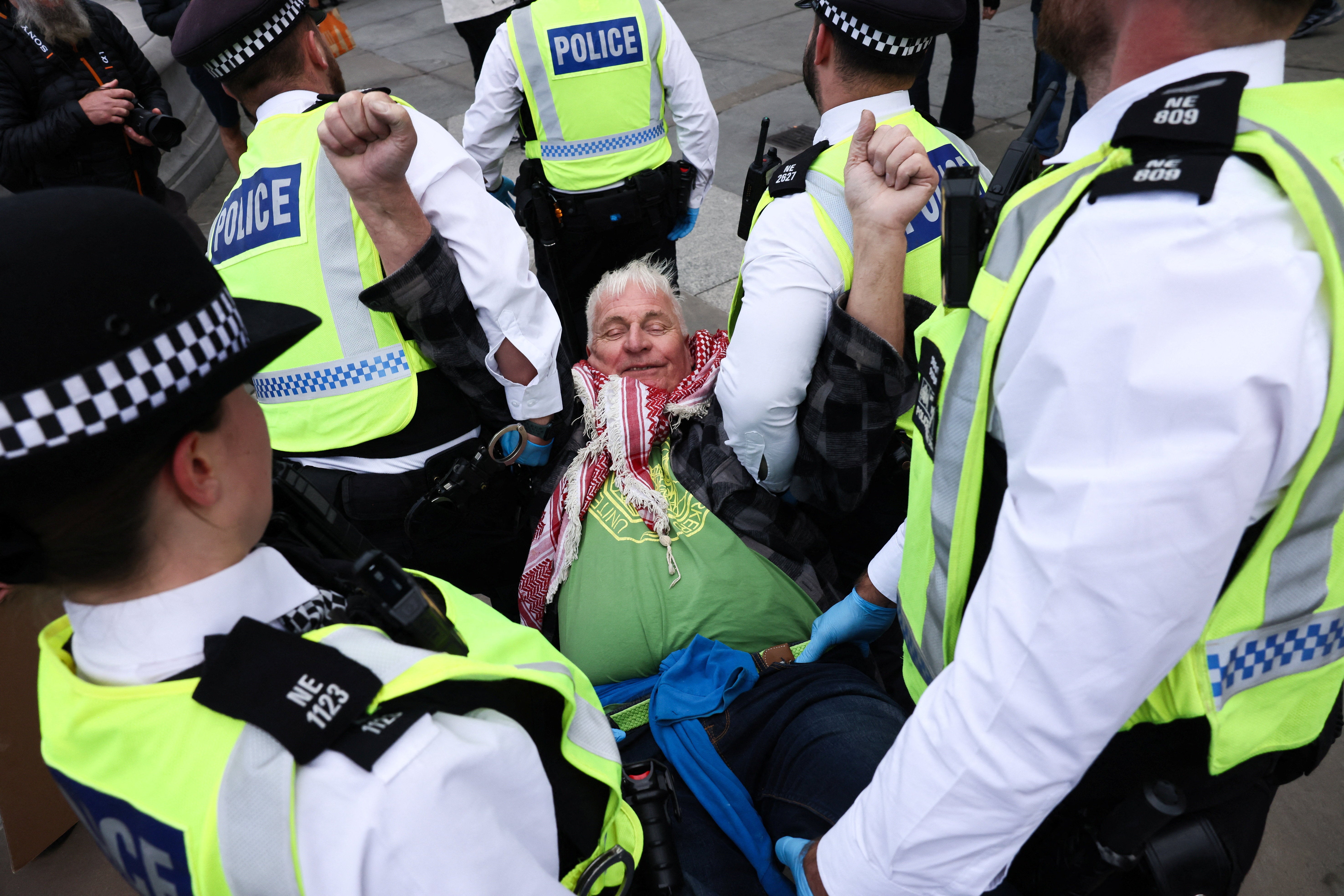 Police officers detain a protester during a mass demonstration organised by Defend our Juries, against the British government's ban on Palestine Action