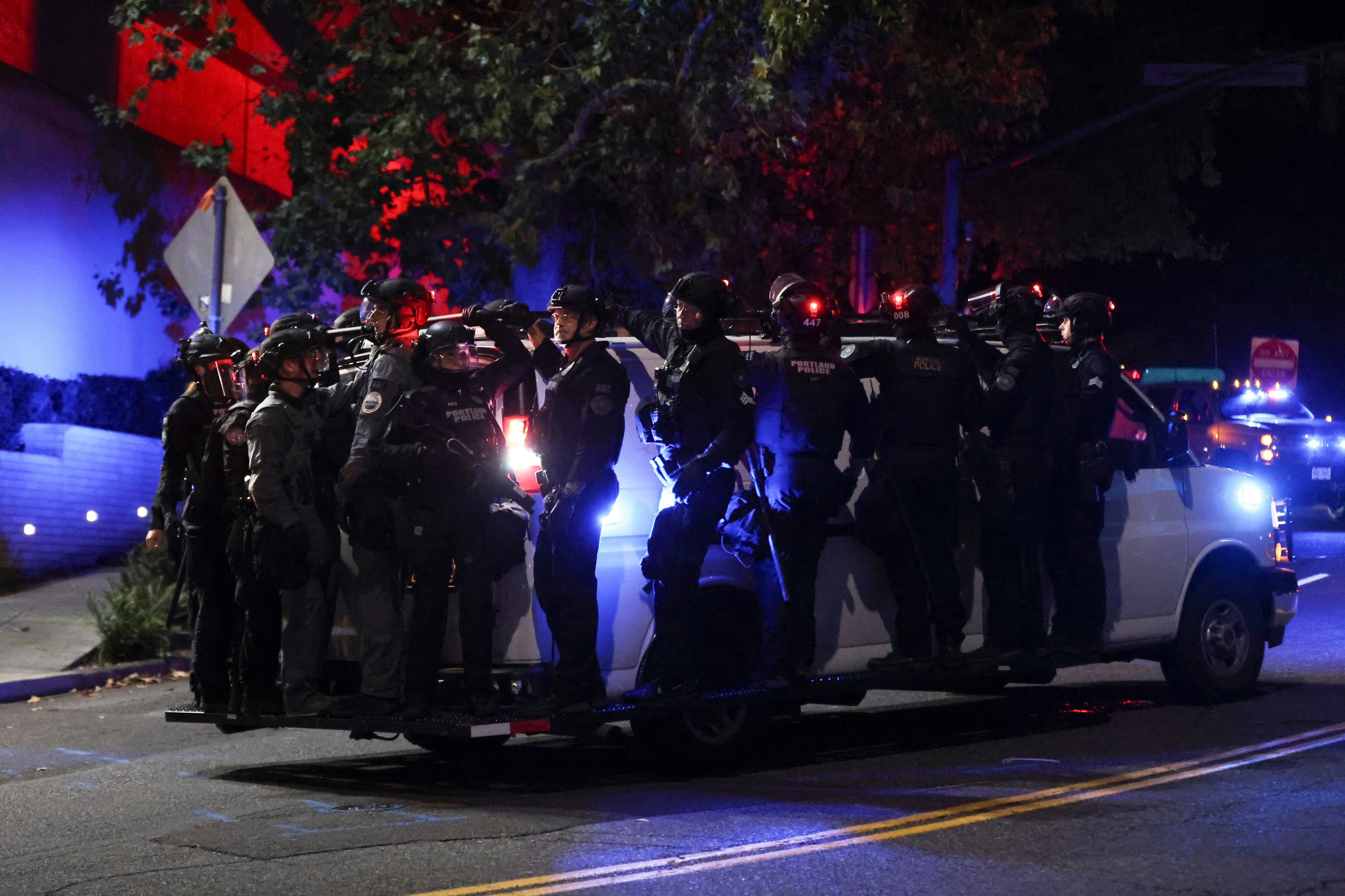 Portland Police load onto a van as people protest outside a U.S. Immigration and Customs Enforcement facility in Portland, Oregon, Friday October 3