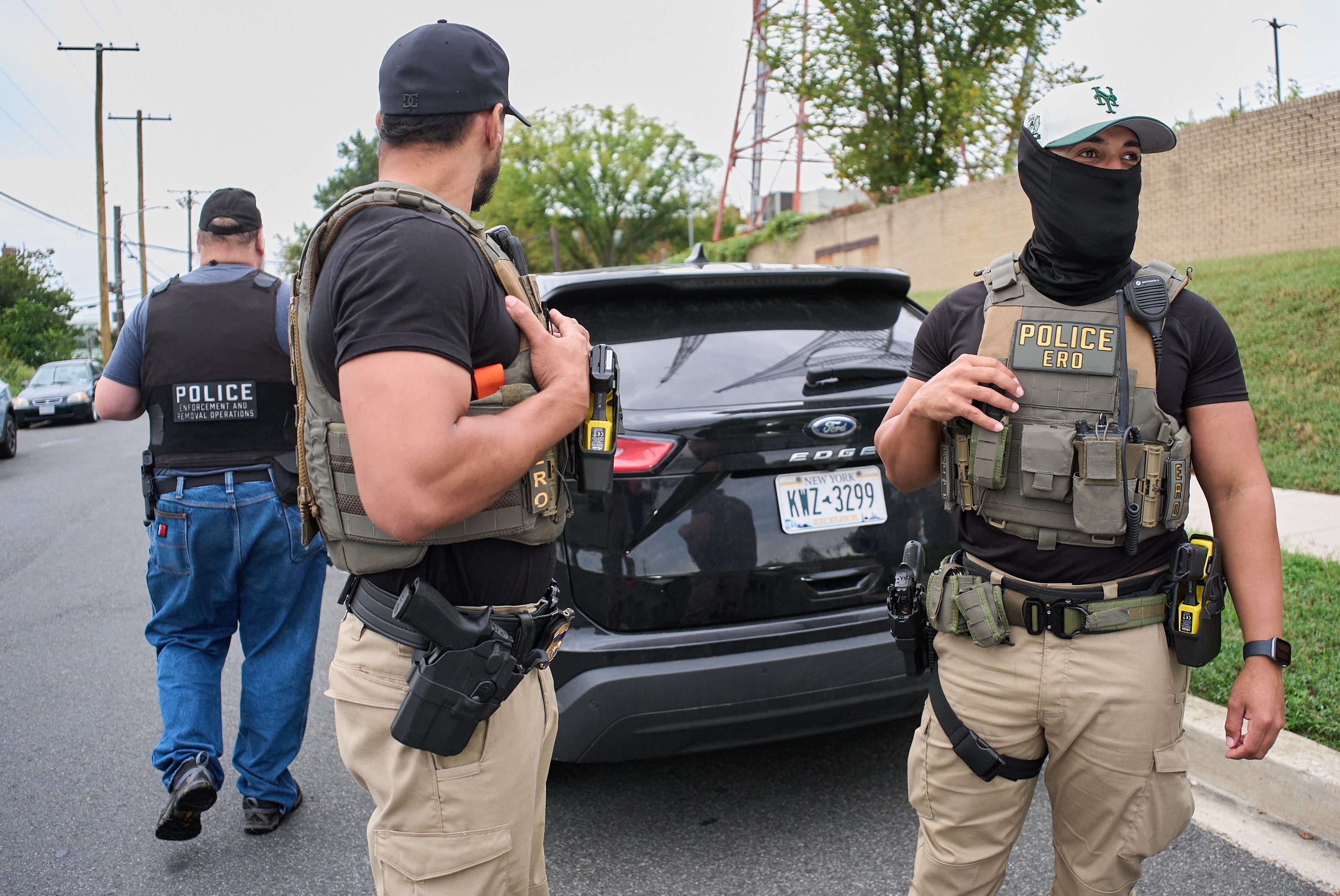 Federal Agents, several with Enforcement and Removal Operations (ERO), a part of U.S. Immigration and Customs Enforcement (ICE), regroup before heading out on an operation, Monday, Sept. 29, 2025, in a residential neighborhood in northwest Washington.