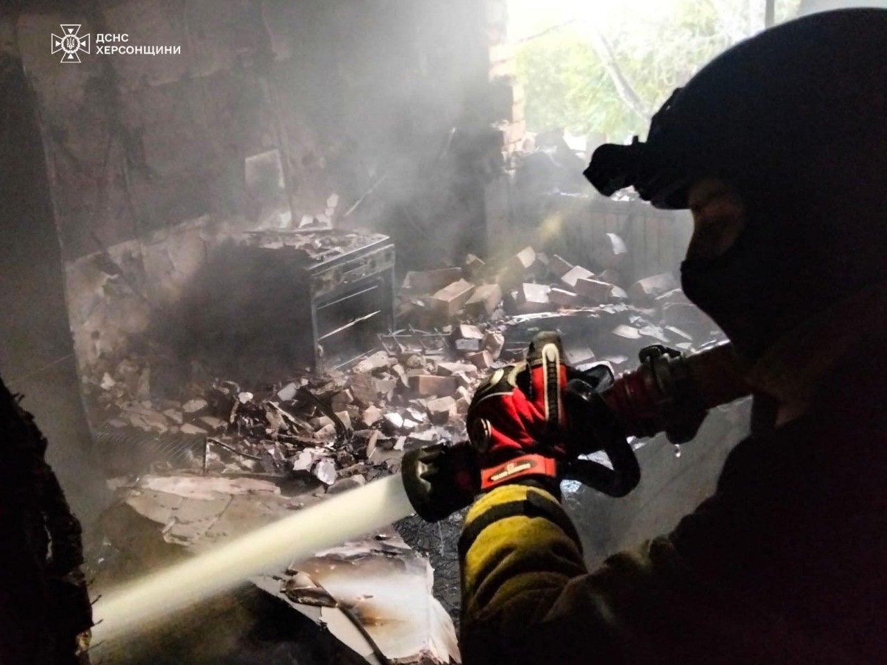A rescuer puts out a fire of a residential house damaged by a Russian strike on Kherson, Ukraine