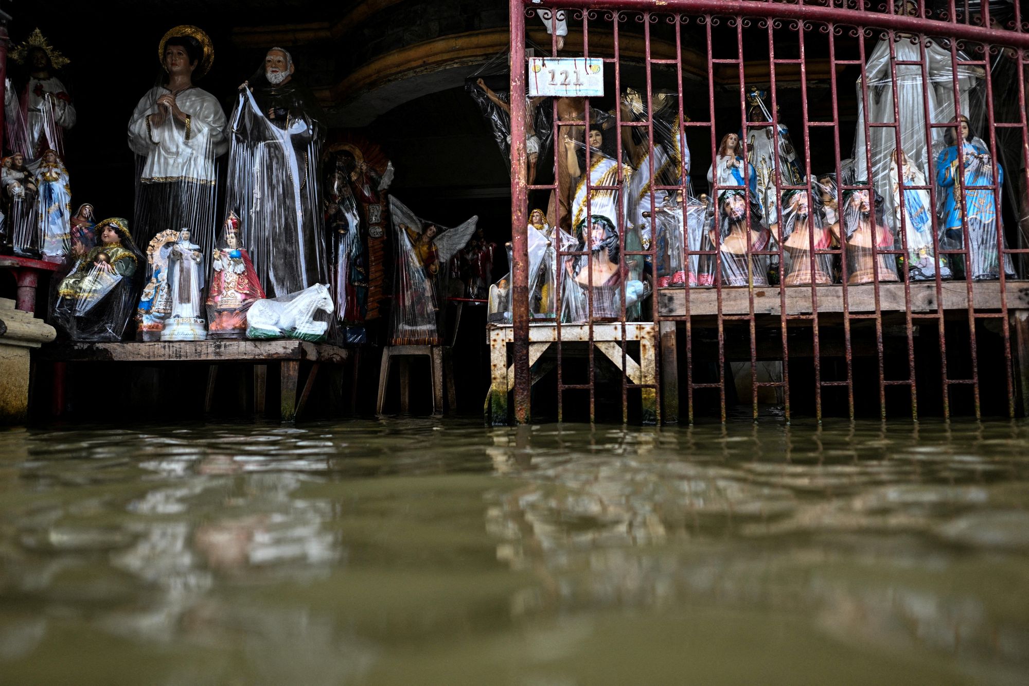 Religious statues made of resin are displayed at a flooded shop, intensified by rain caused by Severe Tropical Storm Matmo, in San Roque, Macabebe, Pampanga, Philippines, 4 October 2025