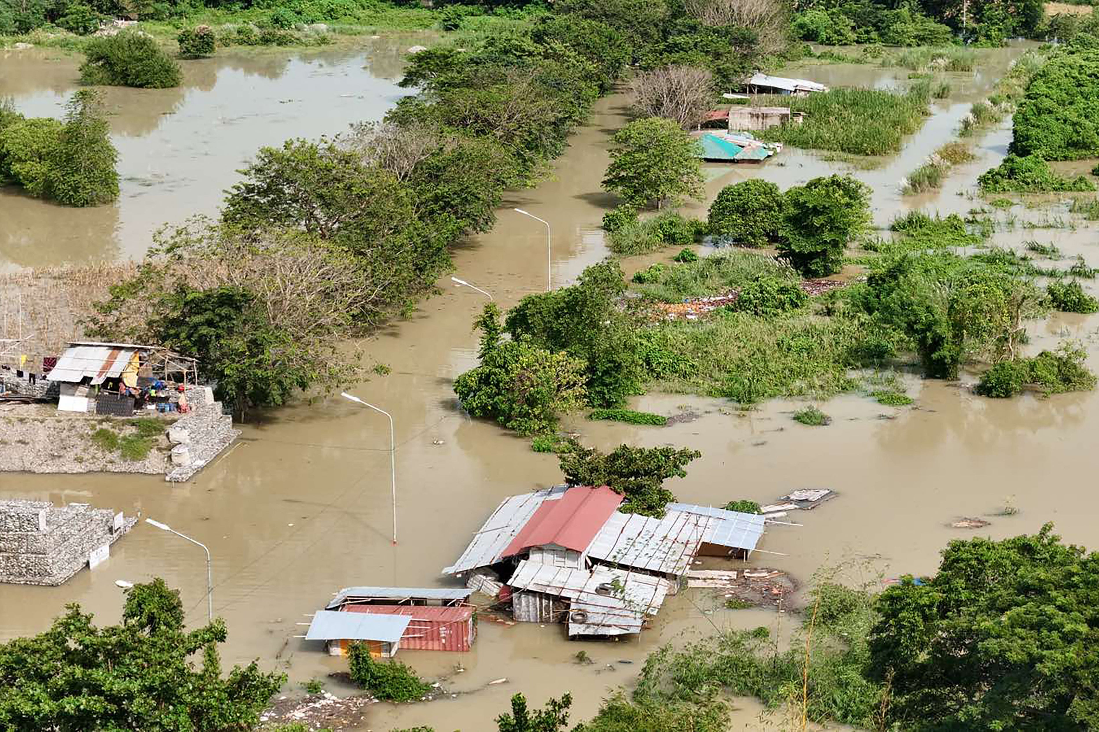 This photo taken on 4 October 2025 shows an aerial view of flooded houses near an inundated river after a dam released waters due to heavy rains brought by Tropical Storm Matmo in Tuguegarao City