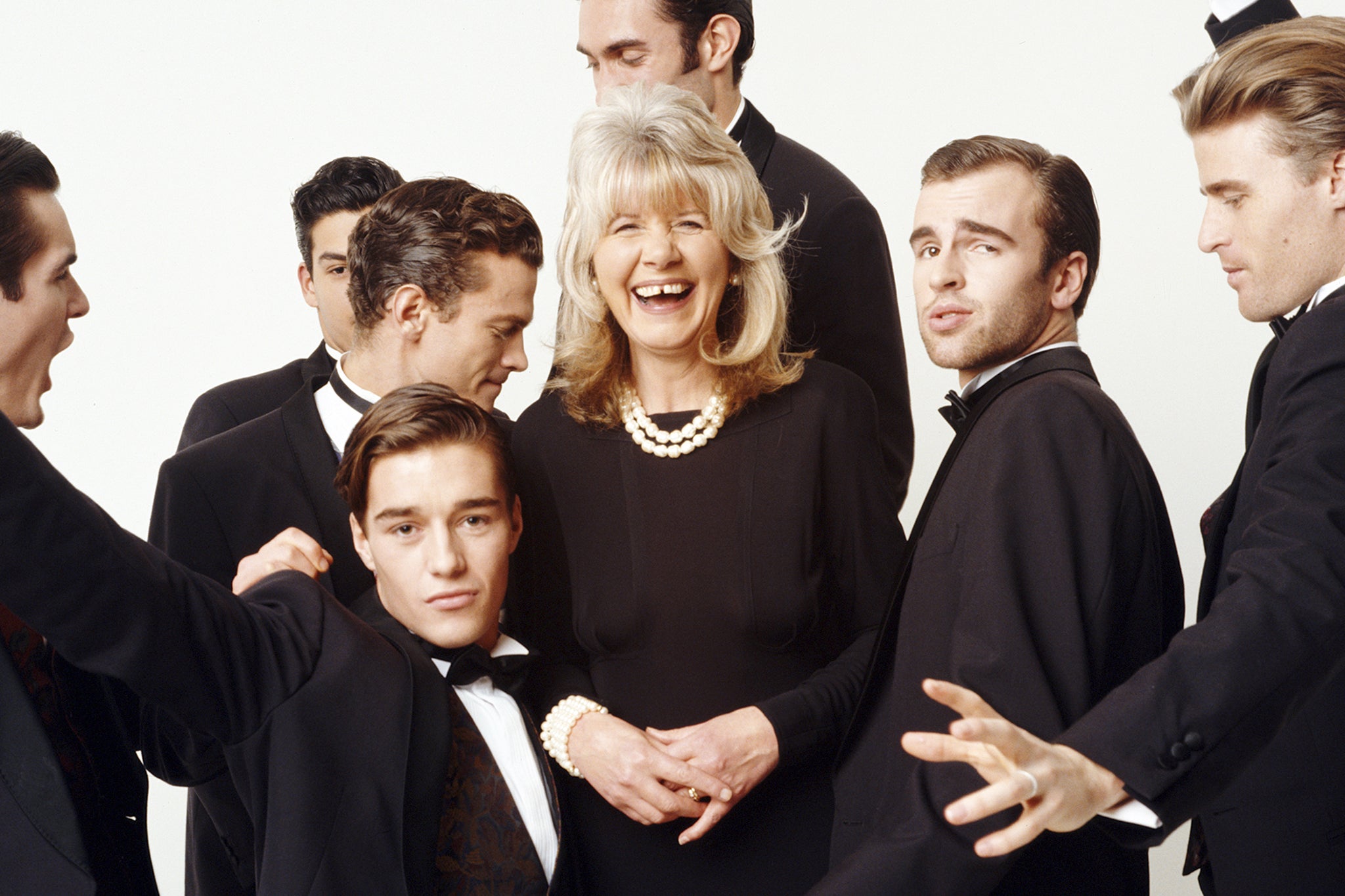 <p>At he peak of her power: English author Jilly Cooper surrounded by eager young men in 1993</p>