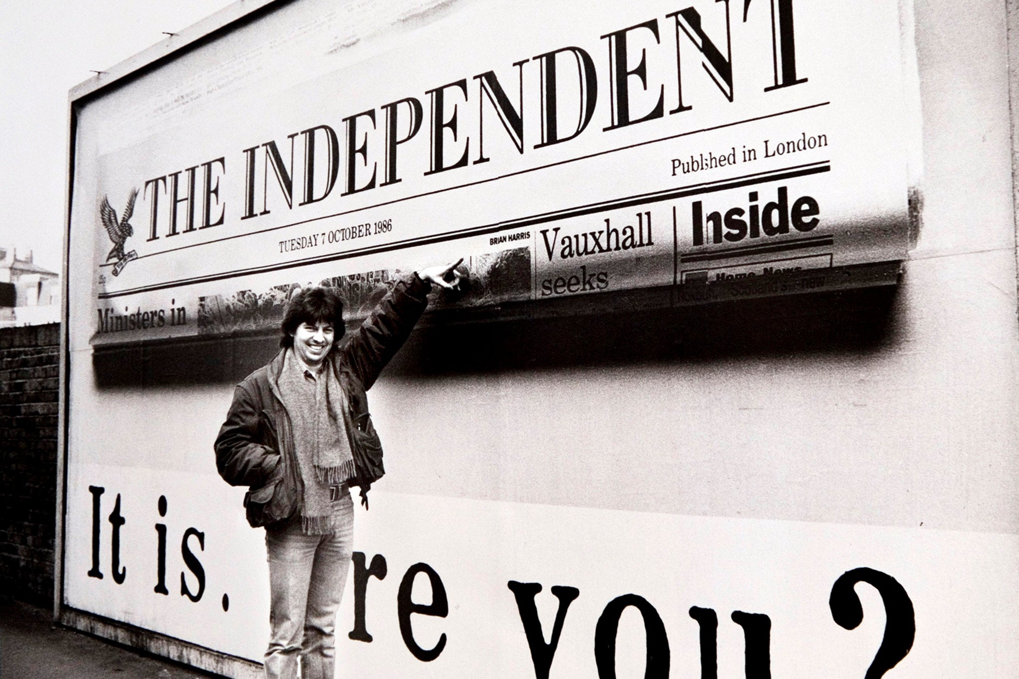 <p>Brian Harris points at his byline credit on a billboard advertising the launch of The Independent in 1986</p>