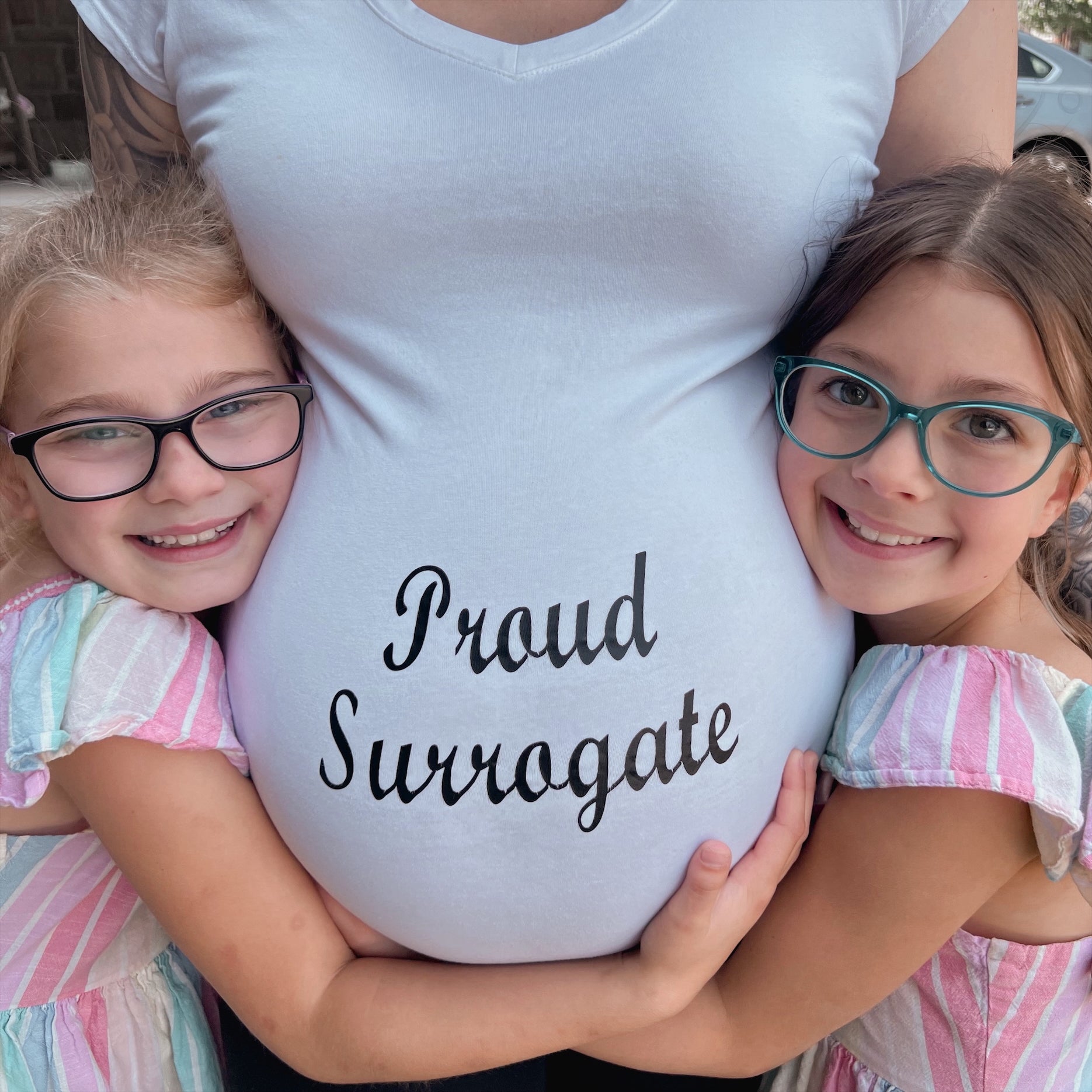 Ariel Taylor’s daughter and stepdaughter pose with her pregnancy bump. Taylor was a gestational surrogate five times and donated her eggs six times to infertile couples