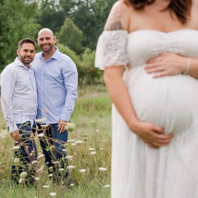 Ariel Taylor poses for a maternity photoshoot during one of her surrogate pregnancies, with the intended parents in the background