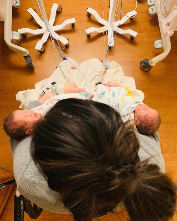Sammi Itatani holds the twins she gave birth to hours before. After implanting one embryo, the egg unexpectedly split and she became a surrogate for identical twin girls to a same-sex couple
