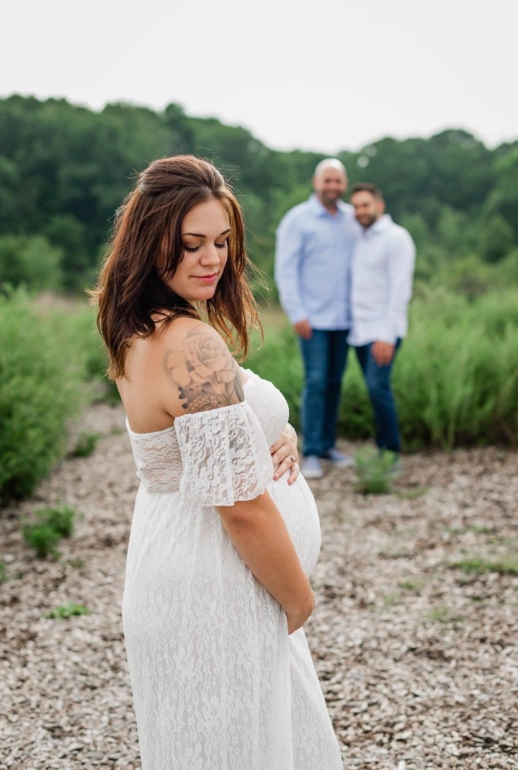 Taken from another perspective, the photo foregrounds Ariel and features the intended parents standing behind