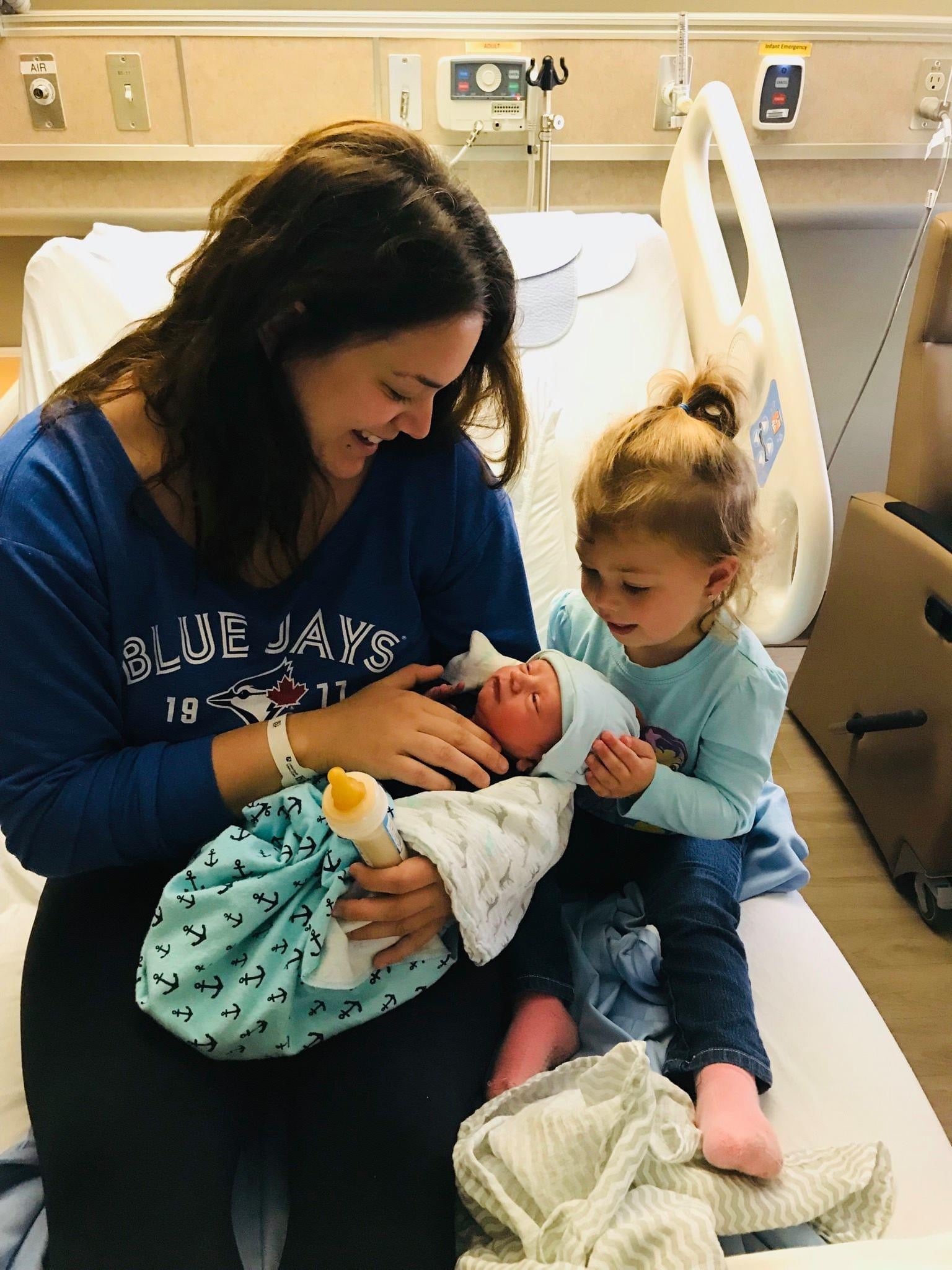 Ariel Taylor introduces her biological daughter to one of her surrogate babies, not long after the baby’s birth. She describes the experience of carrying a surrogate couple’s baby as special, but very different to carrying her own child