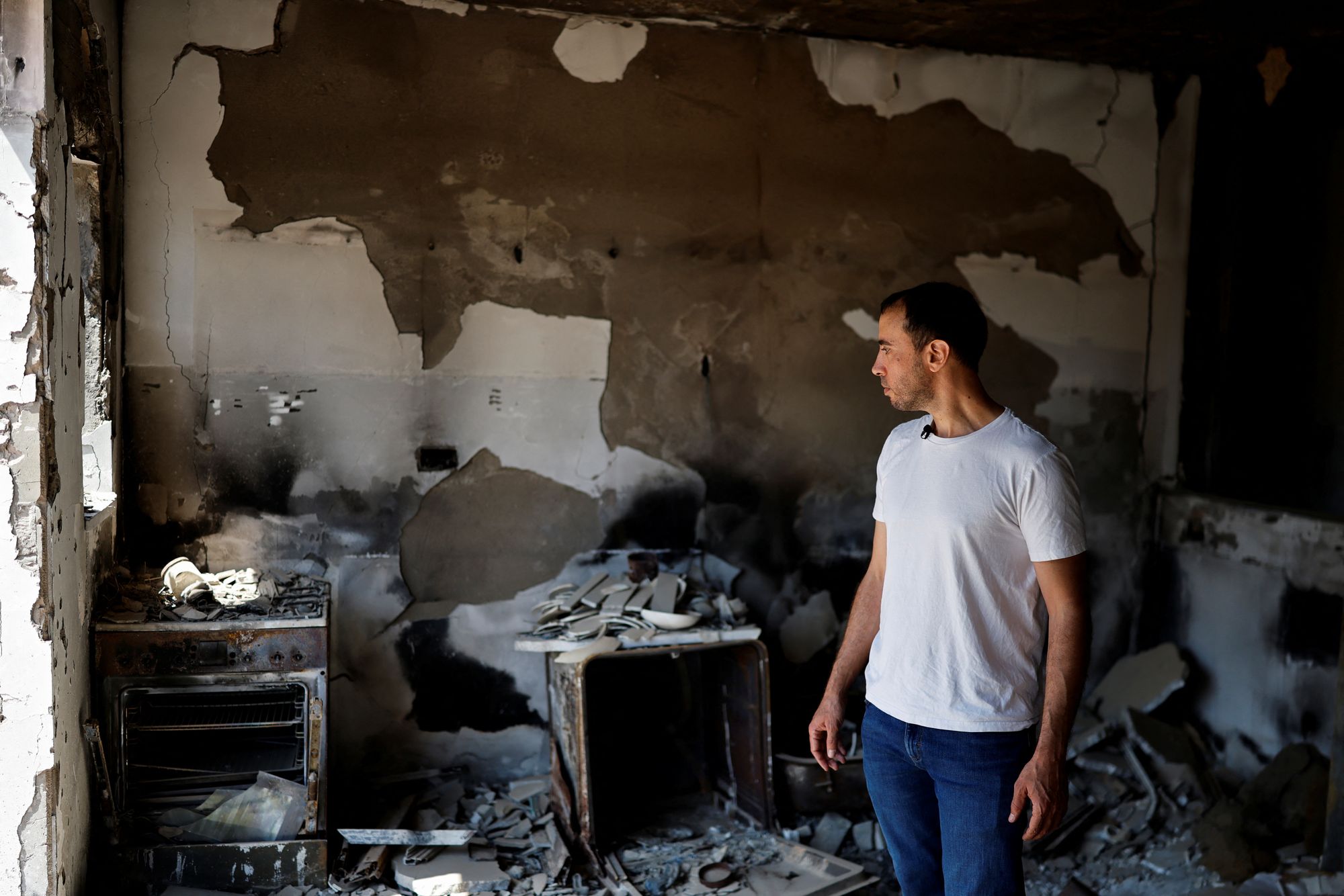 Tal Shoham looks at the damage to the home of his in-laws in Kibbutz Beeri.