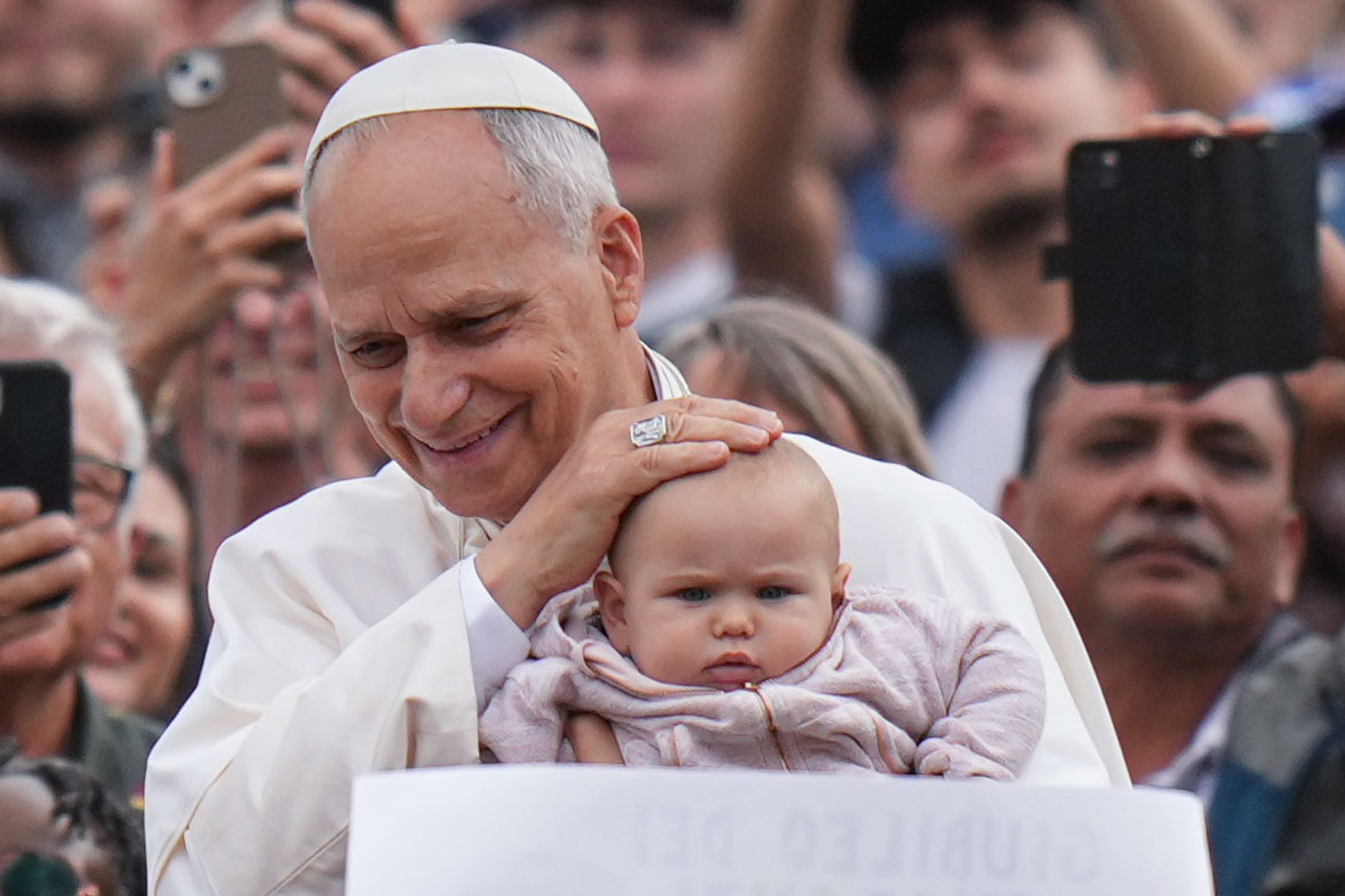 Pope Leo XIV blesses a child at the end of a Mass for the Jubilee of Migrants and Missionaries in St. Peter's Square at the Vatican